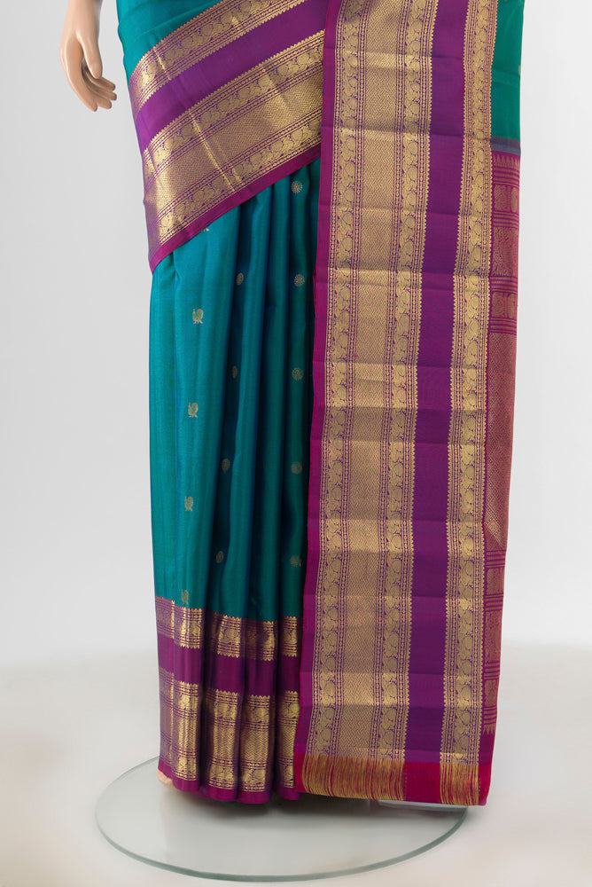 Pleats and pallu of Peacock Blue Kanchipuram Silk Saree with Zari Butta on the body and Zari Border. 
