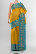 Mustard Kanjivaram Silk Saree with Zari Butta on the body and Silk Border.  displayed on a mannequin