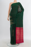 Bottle Green Soft Silk Saree with Zari Butta on the body and Without Border.  displayed on a mannequin