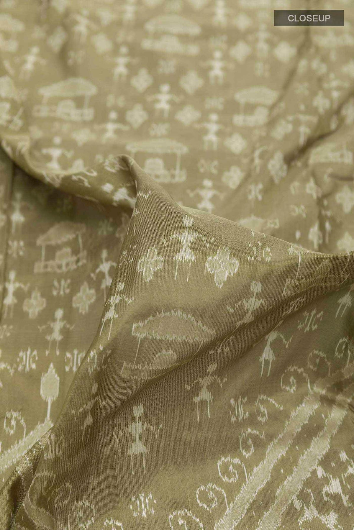 Close up of Olive Green Orissa Silk Saree with Ikat design on the body and Zari Border displaying folds