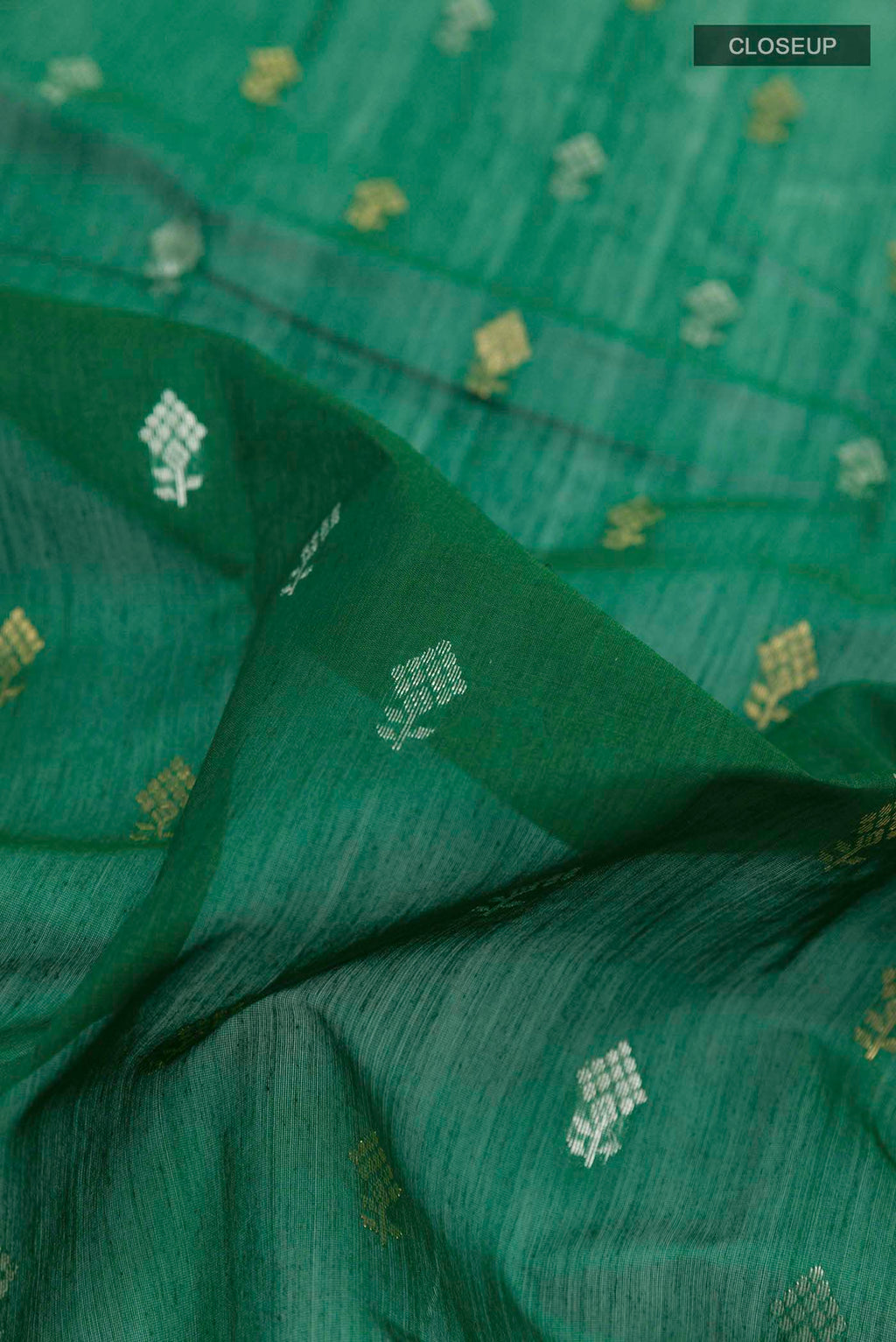 Close up of Green Chanderi Silk Cotton Saree with Zari Butta on the body and Zari Border displaying folds