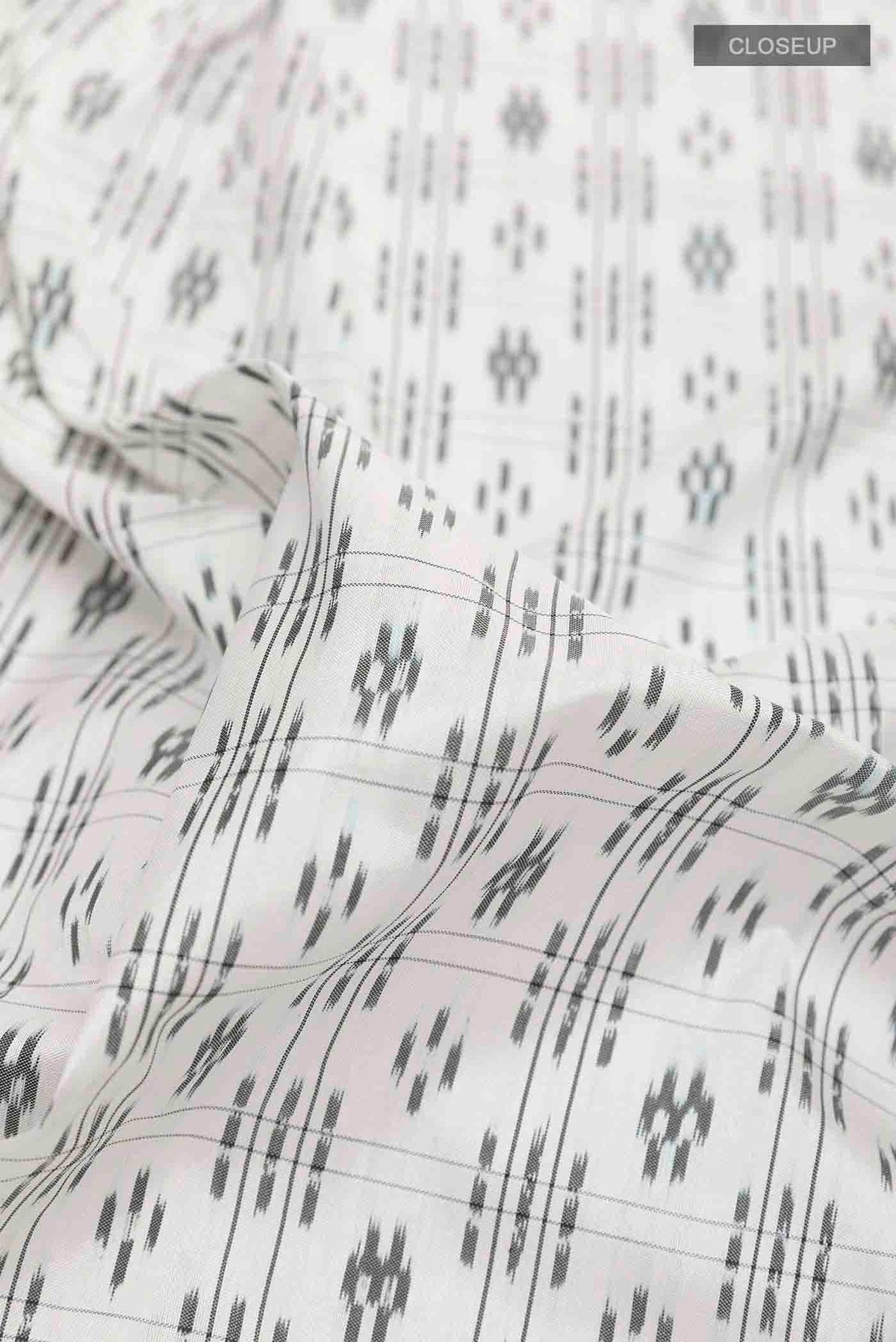 Close up of White Pochampally Silk Saree with Pure Ikat on the body and Plain Border displaying folds