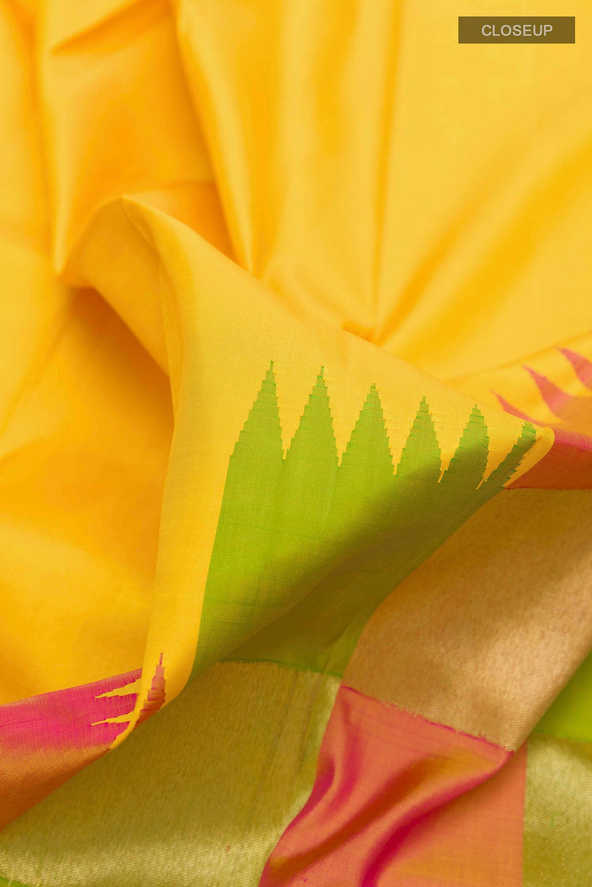 Close up of Yellow Kanchipuram Silk Saree with Plain Body and Rising Temple Border displaying folds
