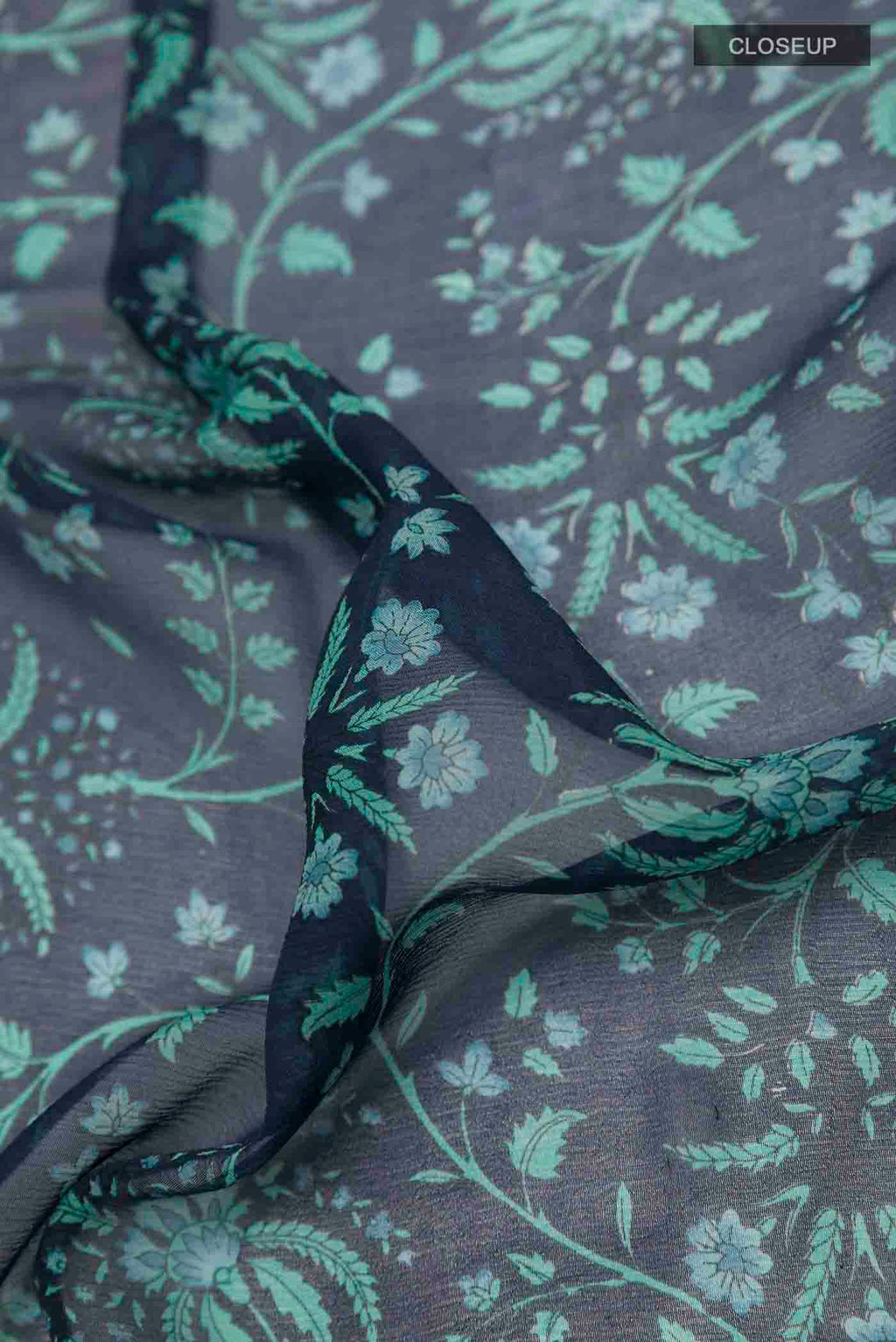 Close up of Peacock Blue Mysore Chiffon Saree with Printed design on the body and Zari Border displaying folds