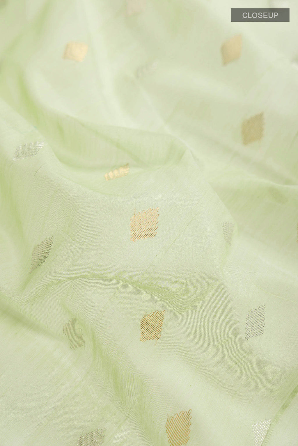Close up of Green Chanderi Silk Cotton Saree with Zari Butta on the body and Zari Border displaying folds
