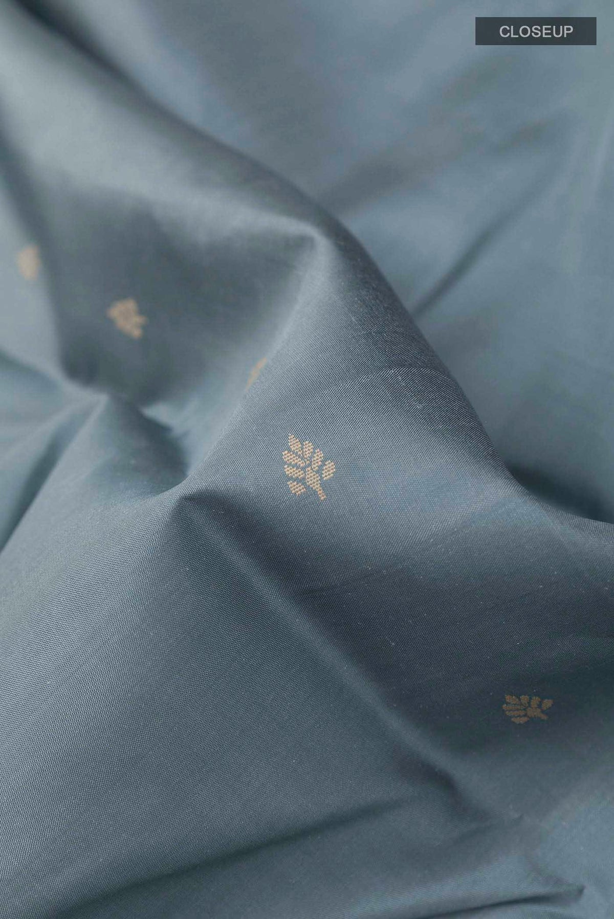Close up of Grey Kanchipuram Silk Saree with Thread Butta on the body and Thread Embroidery Border displaying folds
