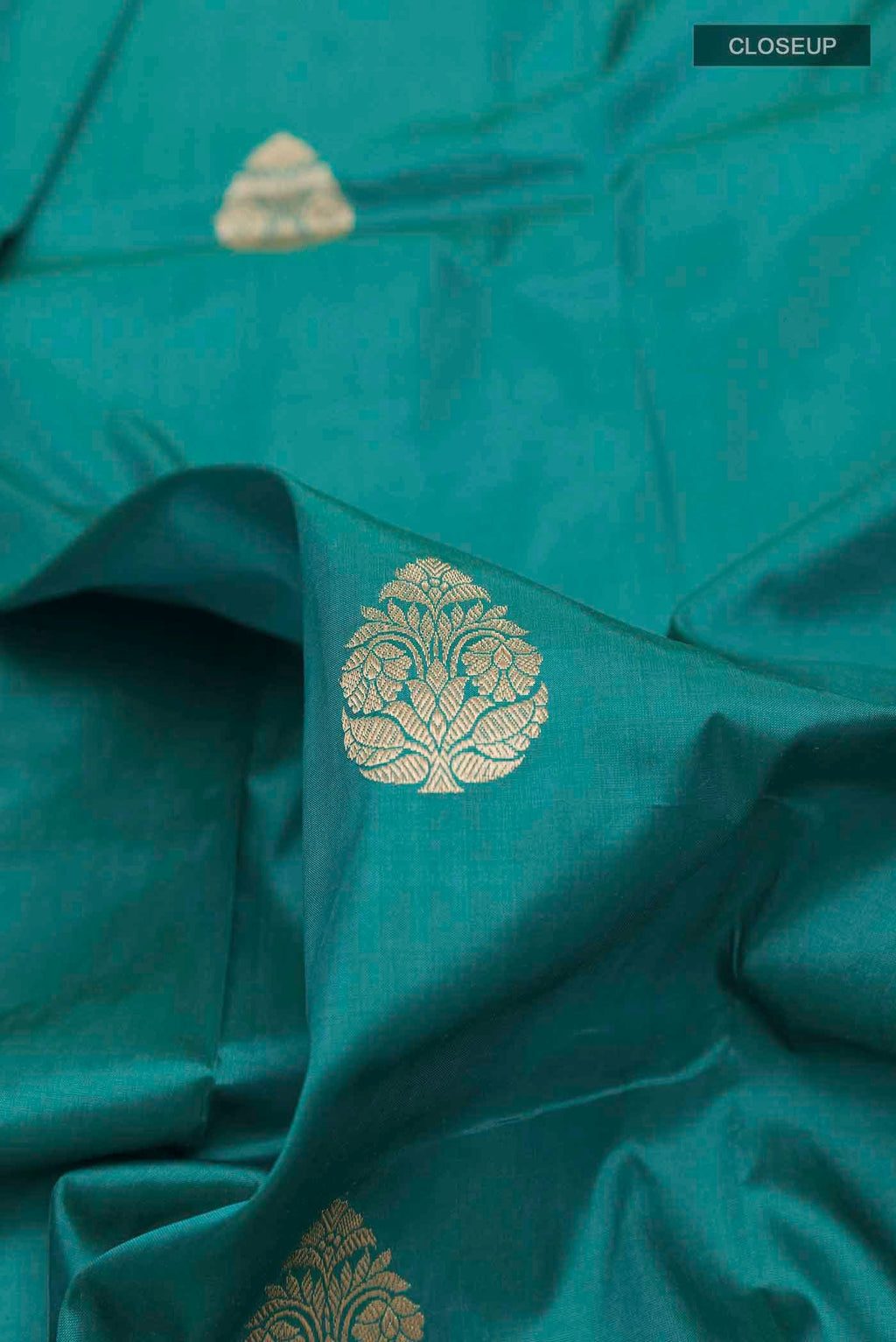 Close up of Sea Green Banarasi Katan Silk Saree with Zari Butta on the body and Zari Border displaying folds