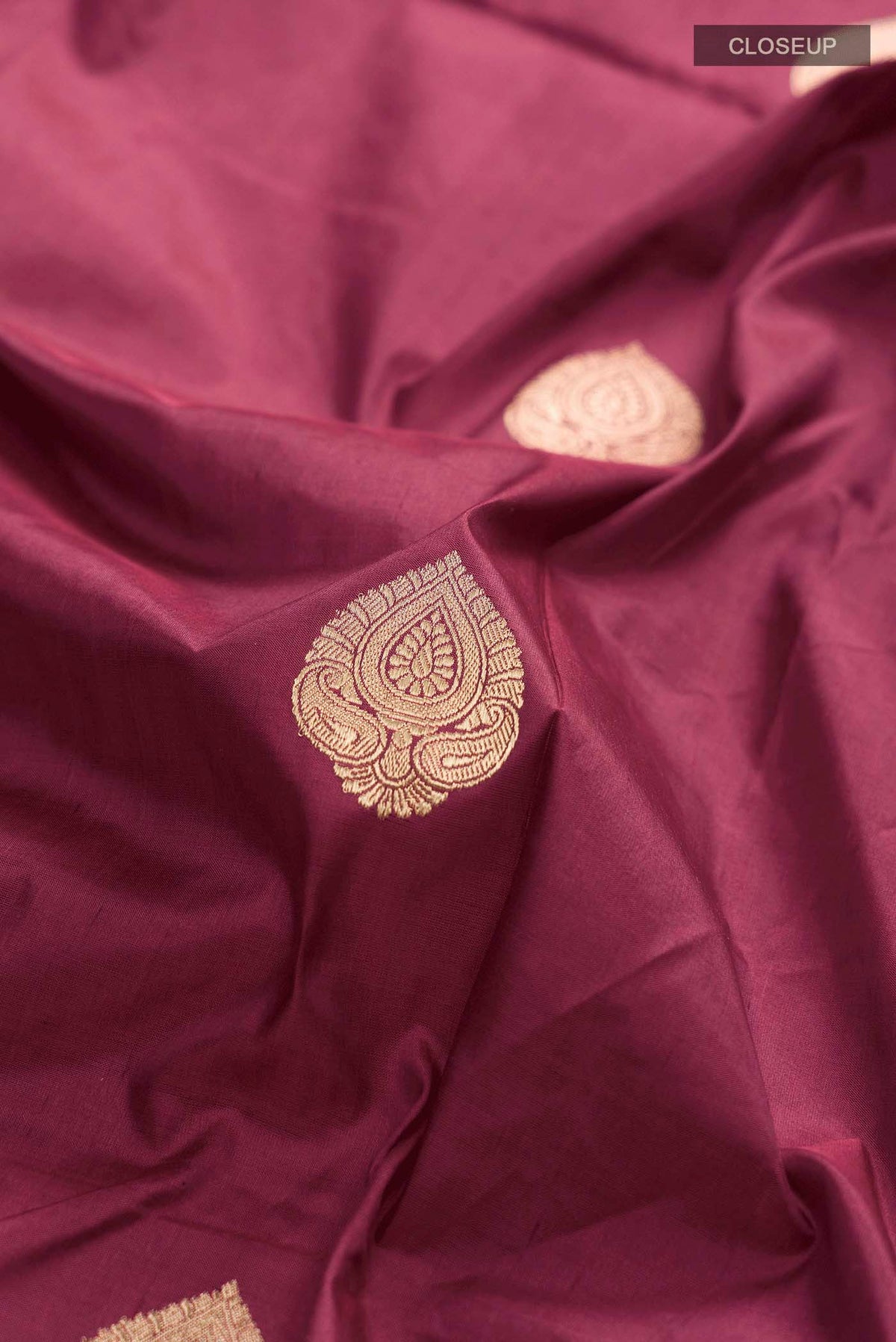 Close up of Maroon Banarasi Katan Silk Saree with Zari Butta on the body and Zari Border displaying folds