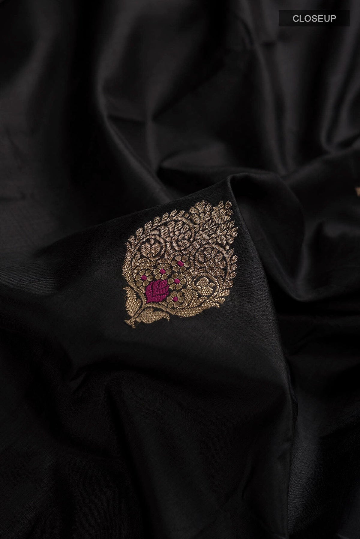 Close up of Black Banarasi Katan Silk Saree with Zari Butta on the body and Zari Border displaying folds