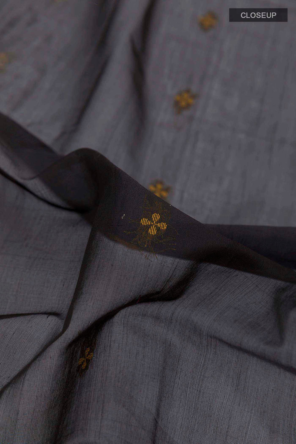 Close up of Black Blended Kora Cotton Saree with Zari And Thread Butta on the body and Zari Border displaying folds