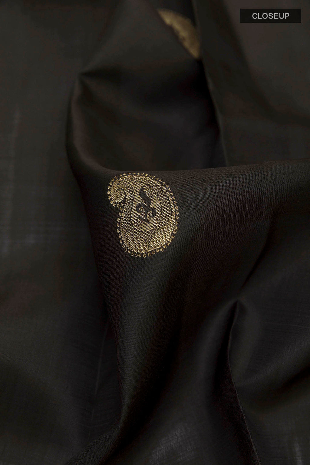 Close up of Black Kanchipuram Silk Saree with Zari Butta on the body and Zari Border displaying folds