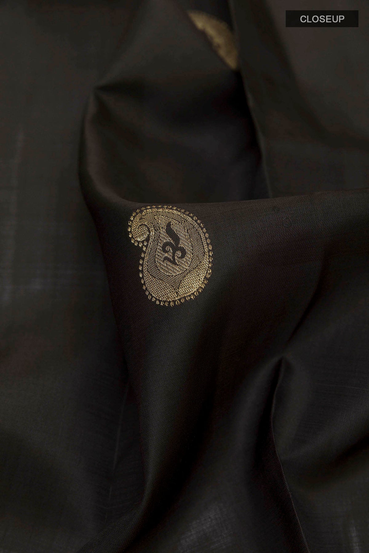 Close up of Black Kanchipuram Silk Saree with Zari Butta on the body and Zari Border displaying folds