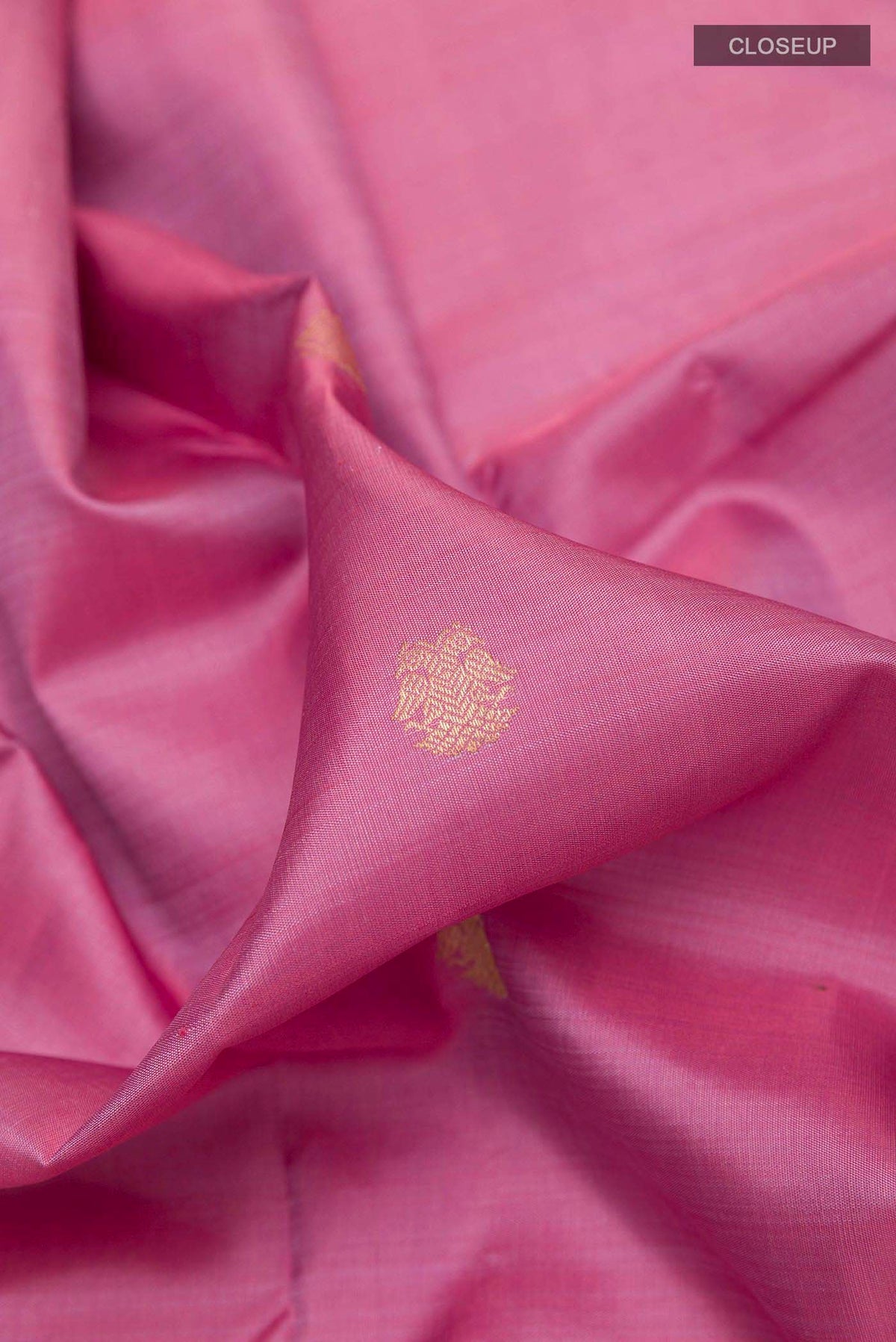 Close up of Pink Kanchipuram Silk Saree with Zari Butta on the body and Zari Border displaying folds