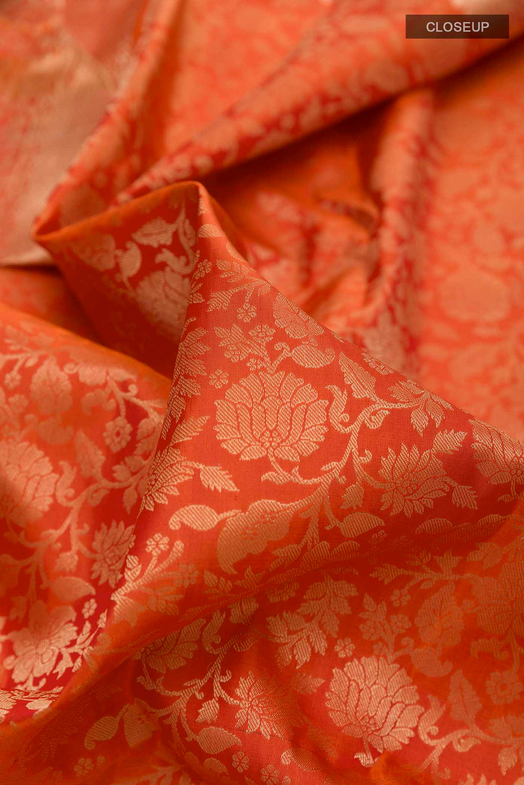 Close up of Orange Soft Silk Saree with Zari Brocade on the body and Zari Border displaying folds