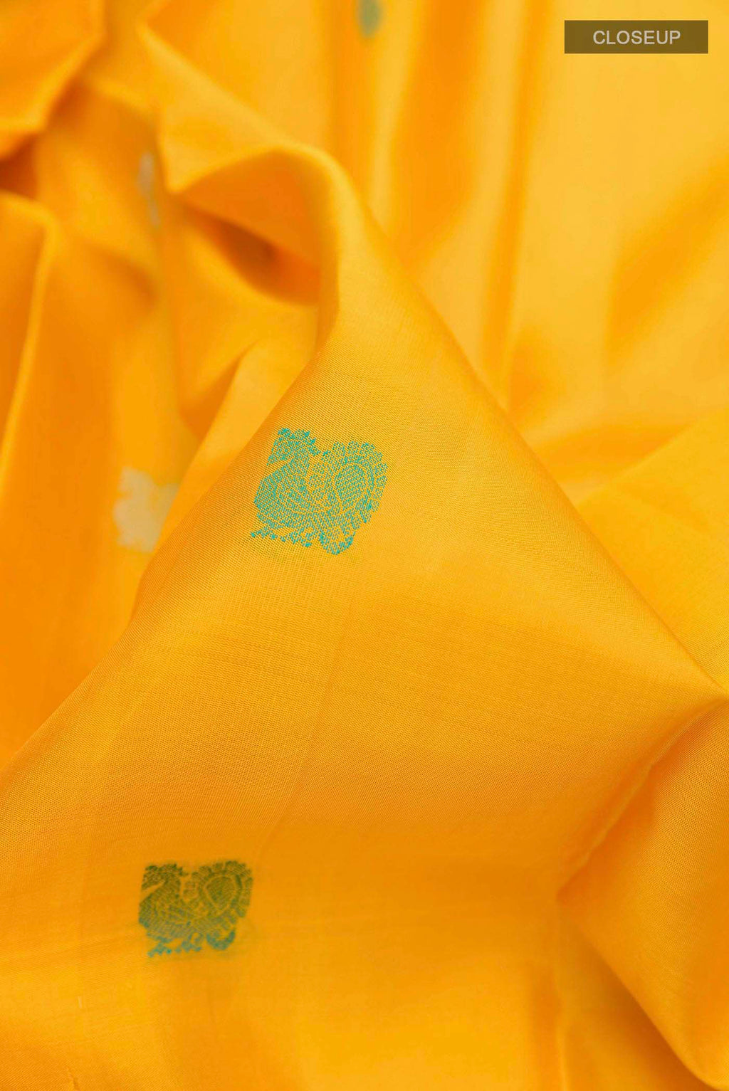 Close up of Yellow Kanchipuram Silk Saree with Thread Butta on the body and Zari And Thread Border displaying folds