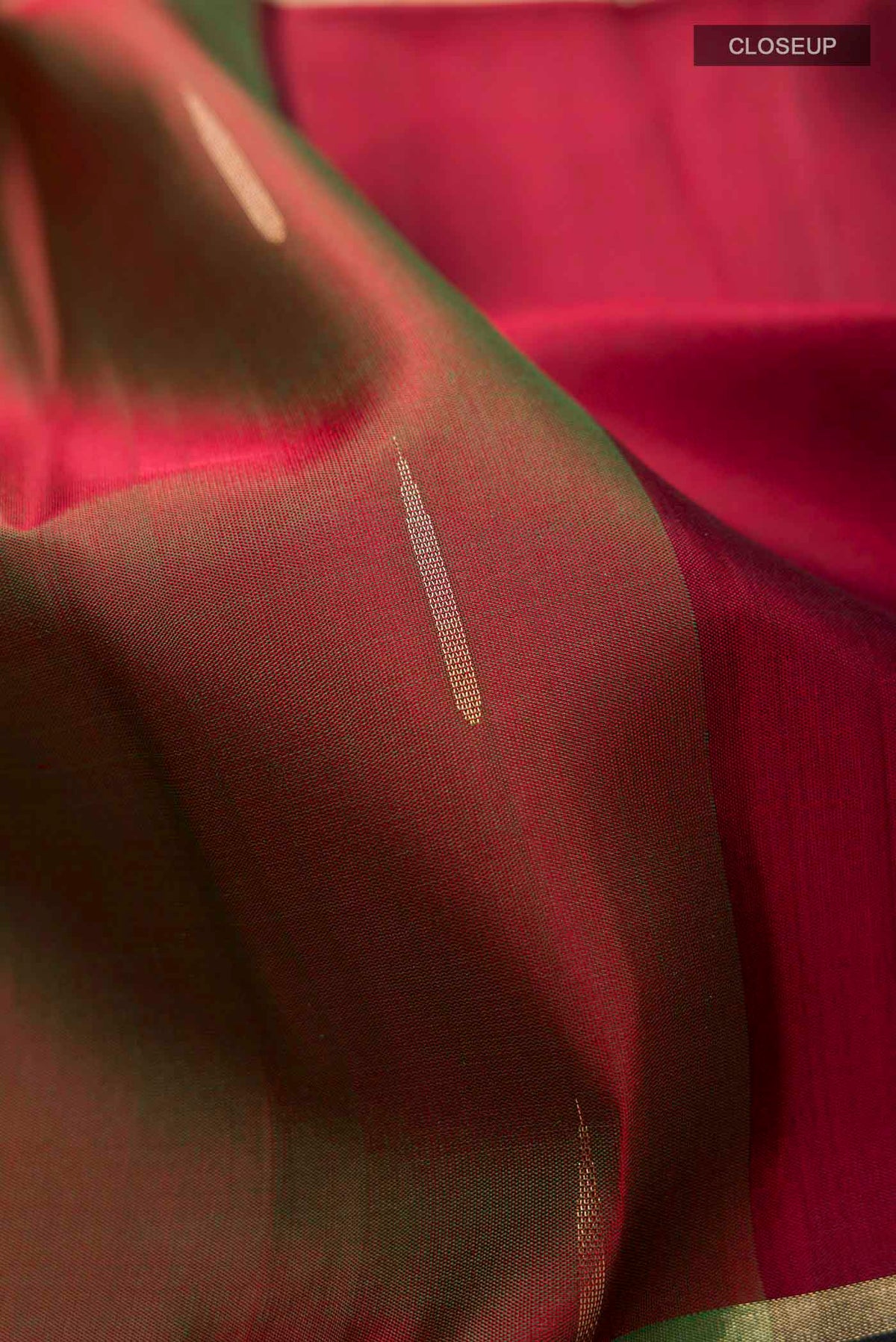 Close up of Green Soft Silk Saree with Zari Butta on the body and Zari Border displaying folds