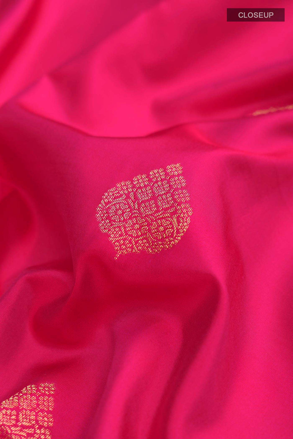 Close up of Pink Soft Silk Saree with Zari Butta on the body and Zari Border displaying folds