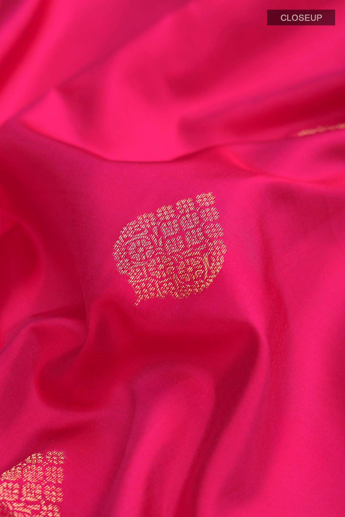Close up of Pink Soft Silk Saree with Zari Butta on the body and Zari Border displaying folds