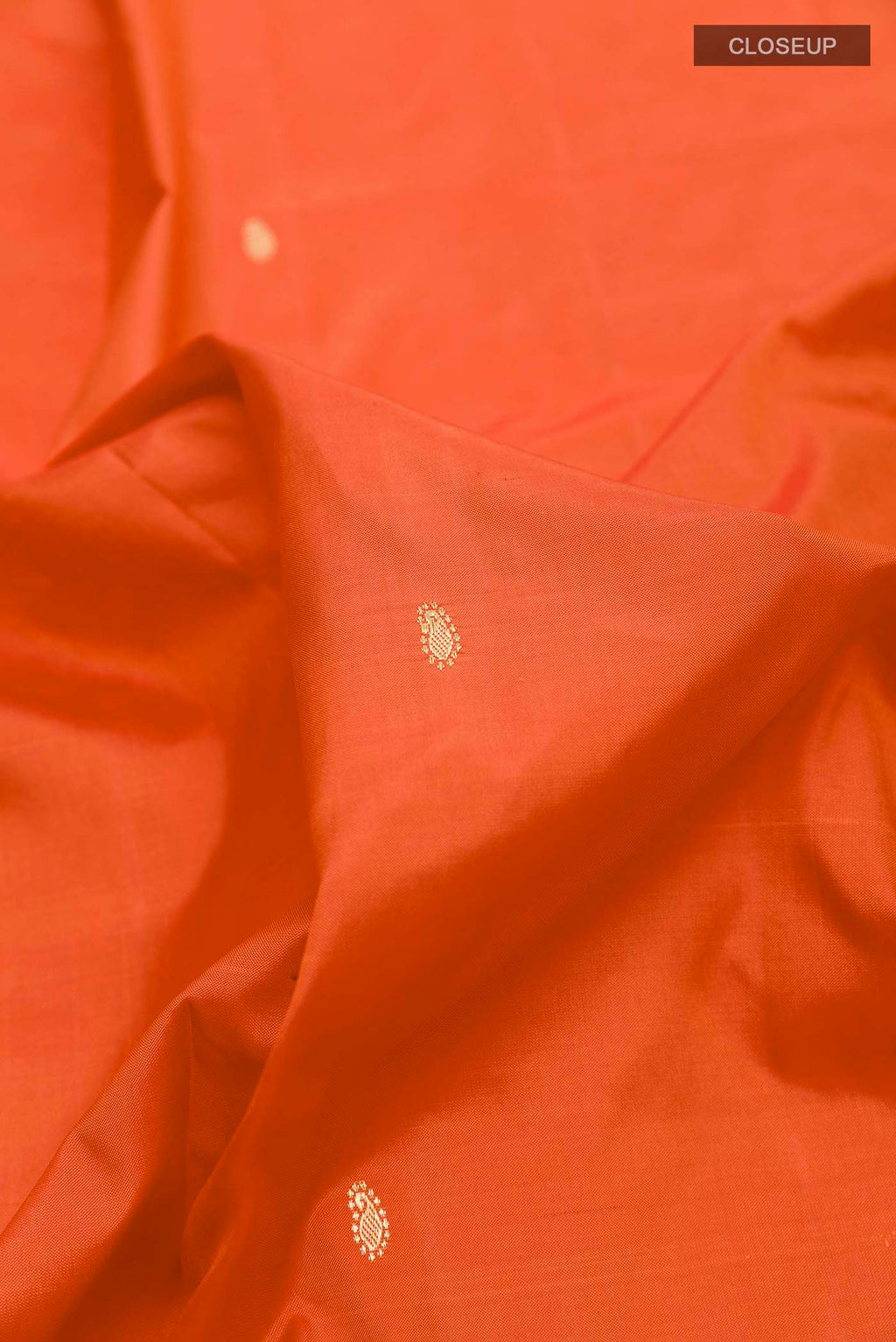 Close up of Orange Paithani Silk Saree with Zari Butta on the body and Zari Border displaying folds