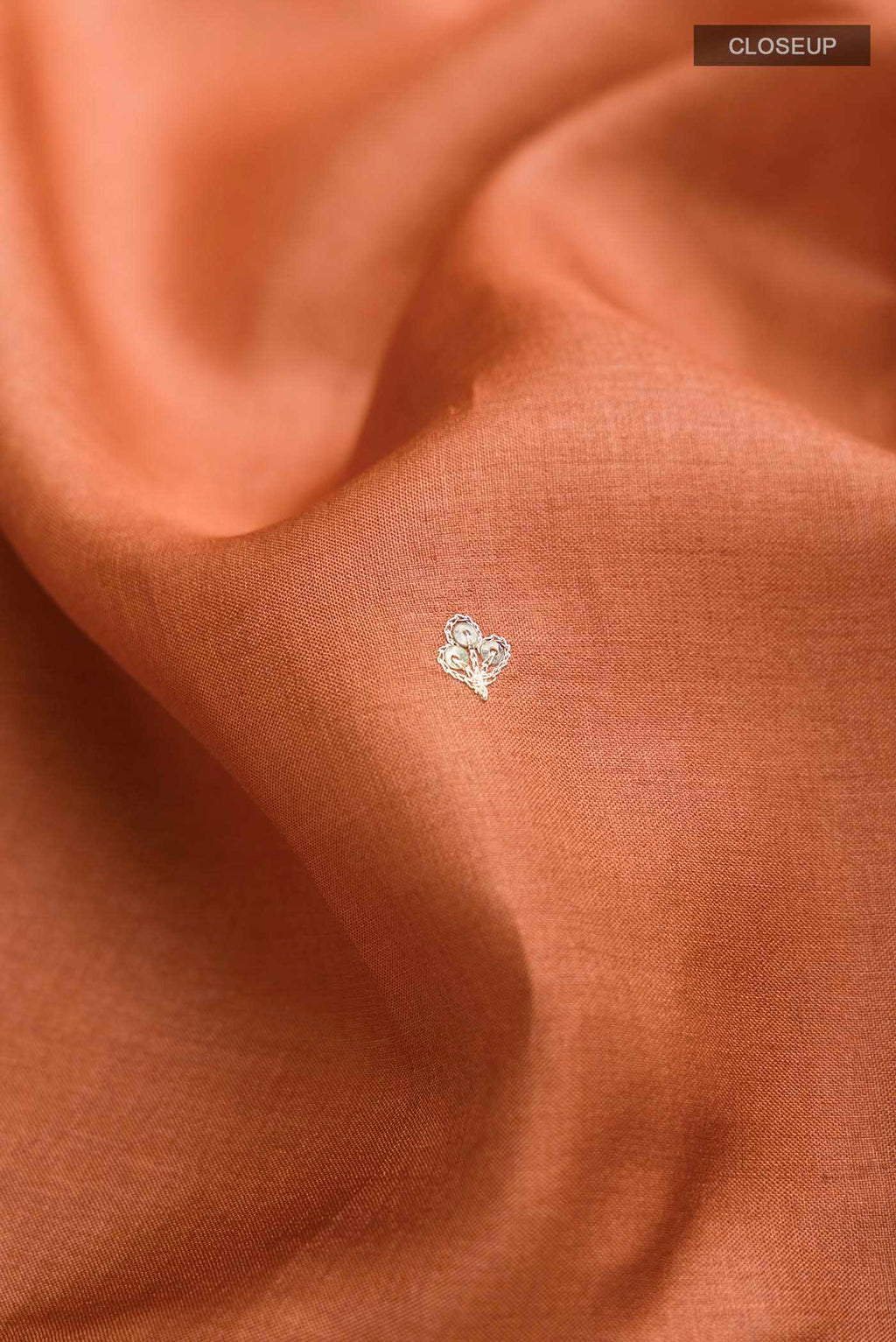 Close up of Rust Bhagalpuri Tussar Silk Saree with Embroidery on the body and Embroidery Border displaying folds