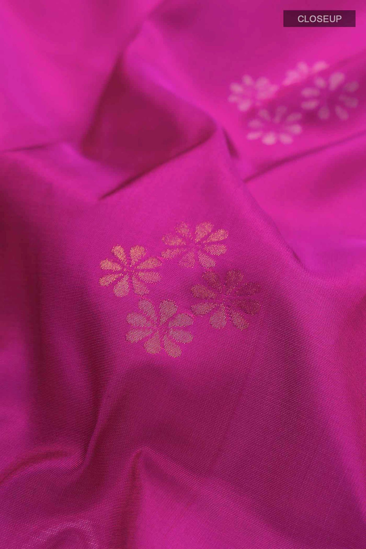 Close up of Magenta Uppada Silk Saree with Zari Butta on the body and Zari Border displaying folds