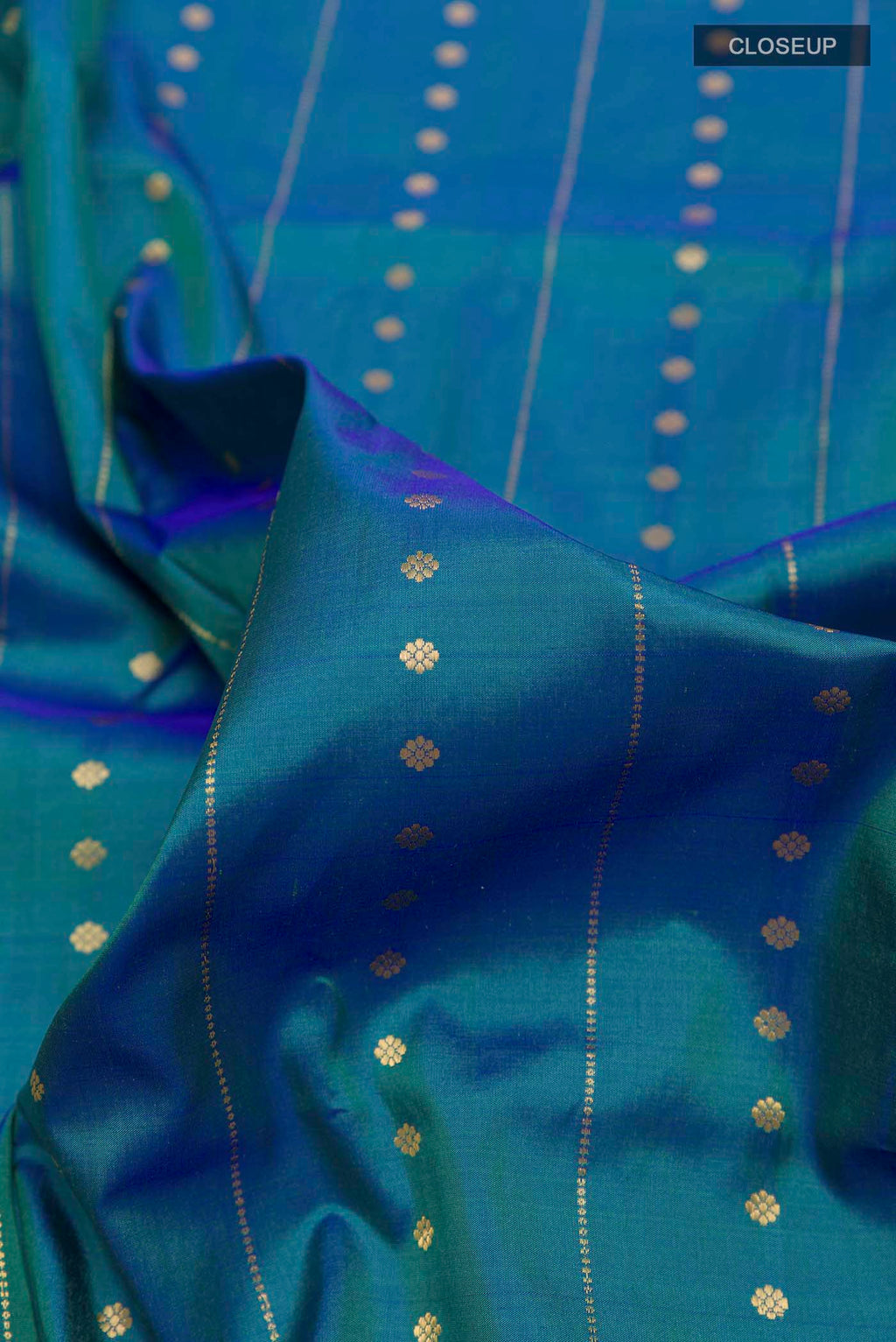 Close up of Peacock Blue Dual Tone Soft Silk Saree with Stripes on the body and Zari Border displaying folds