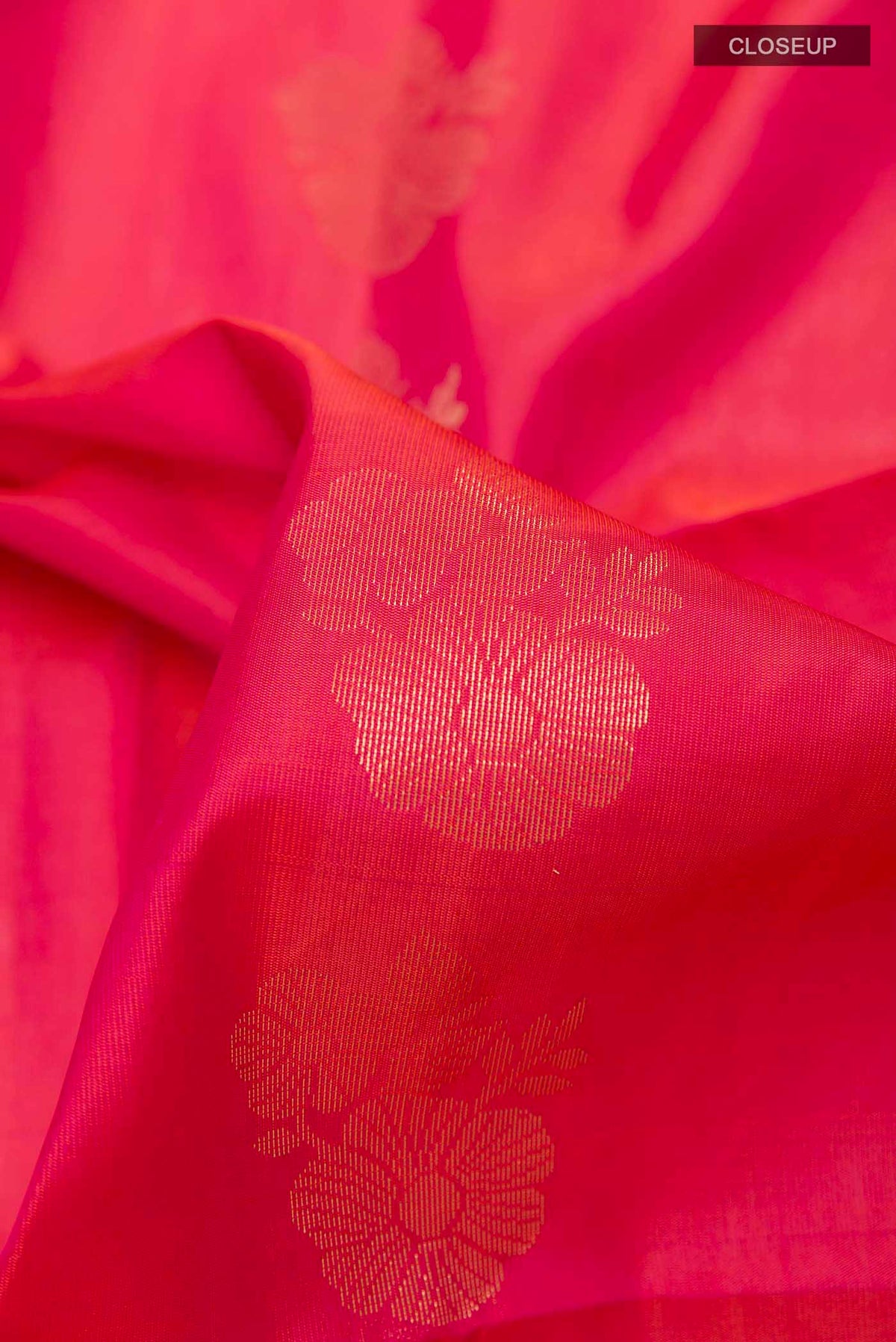 Close up of Pink Dual Tone Soft Silk Saree with Zari Butta on the body and Zari Border displaying folds