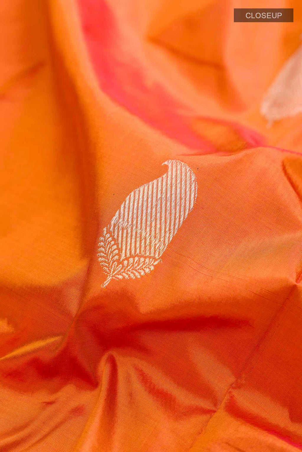 Close up of Orange Banarasi Katan Silk Saree with Zari Butta on the body and Zari Border displaying folds