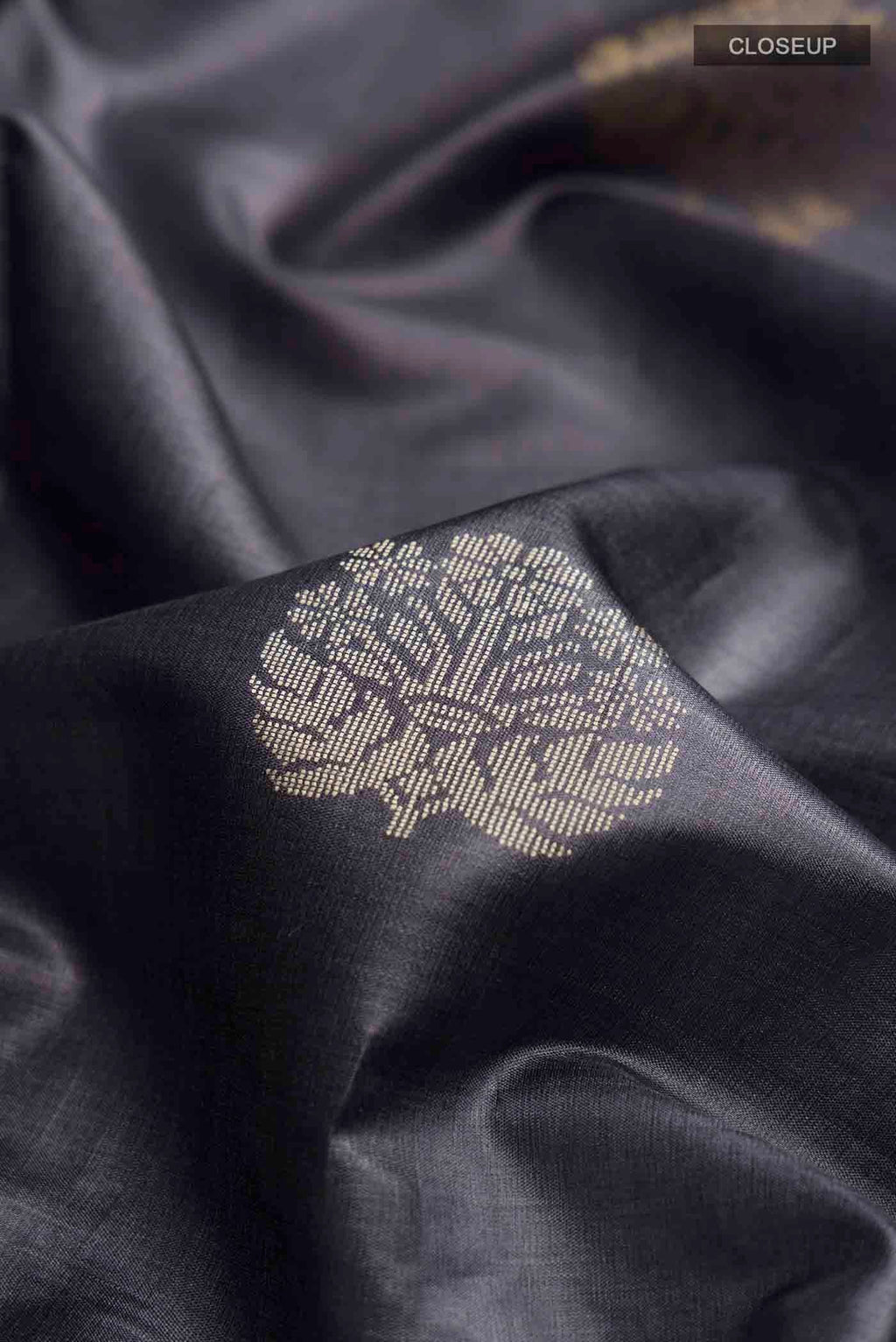 Close up of Grey Tussar Silk Saree with Zari And Thread Butta on the body and Thread Border displaying folds