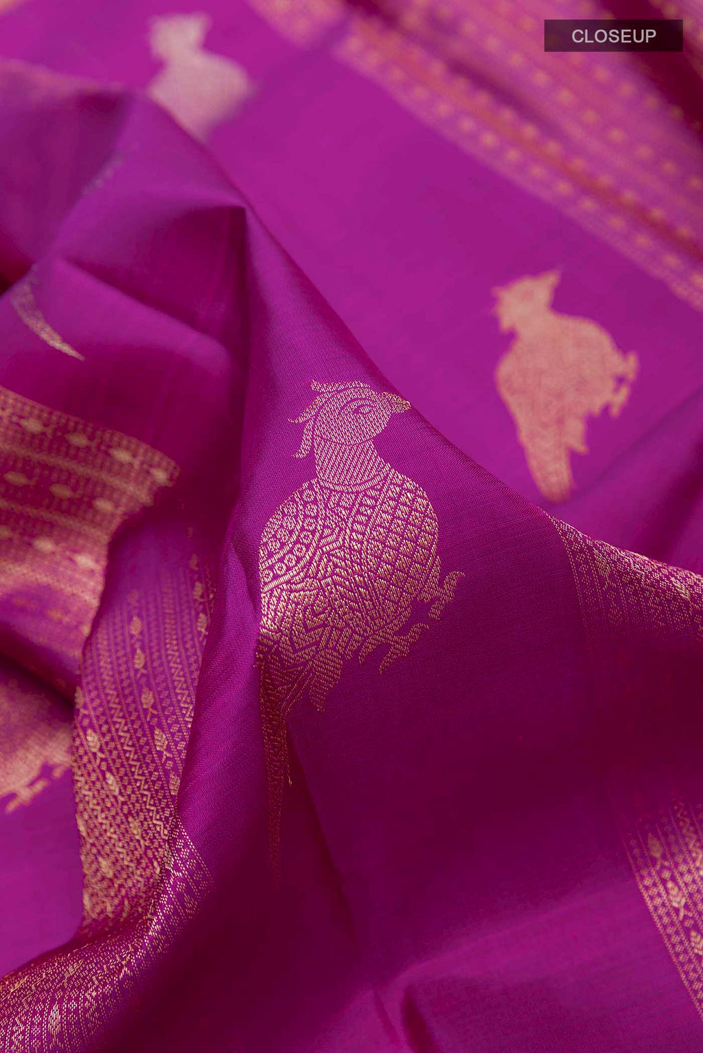 Close up of Purple Kanchipuram Silk Saree with Zari Butta on the body and Zari Border displaying folds