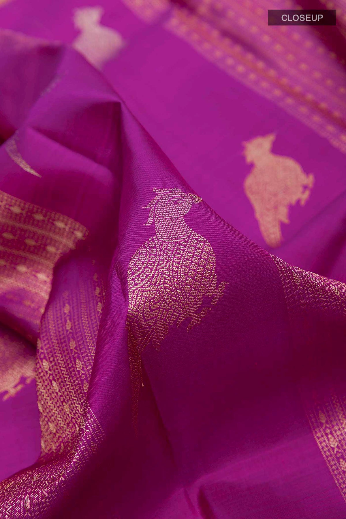 Close up of Purple Kanchipuram Silk Saree with Zari Butta on the body and Zari Border displaying folds