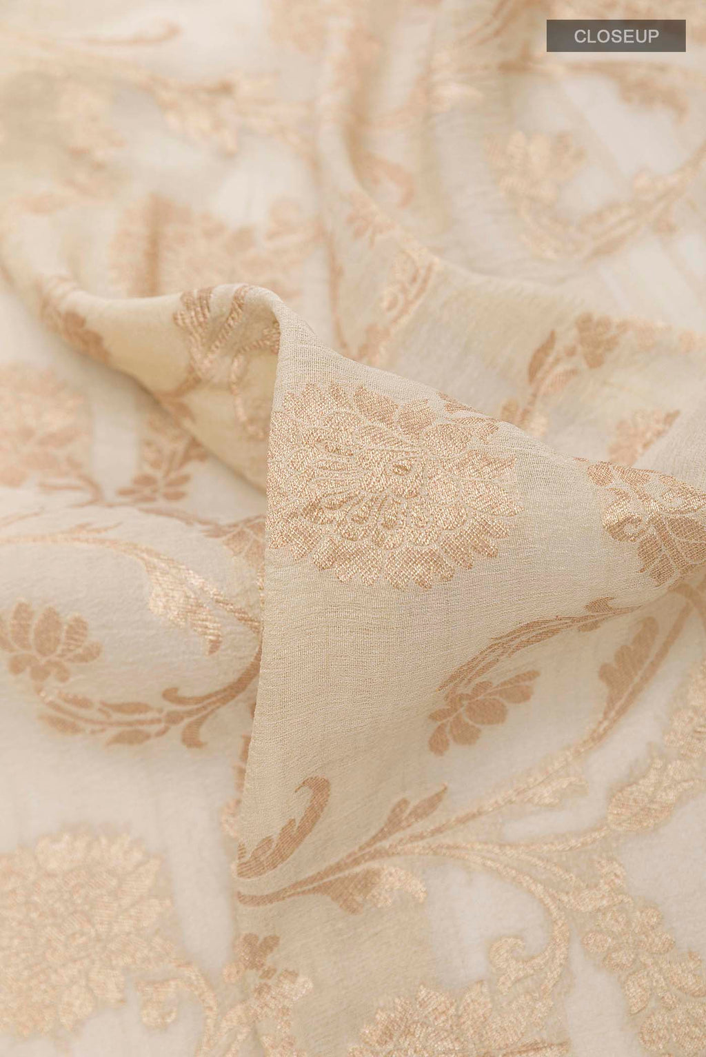 Close up of Off White Banarasi Tussar Georgette Saree with Zari Brocade on the body and Zari Border displaying folds