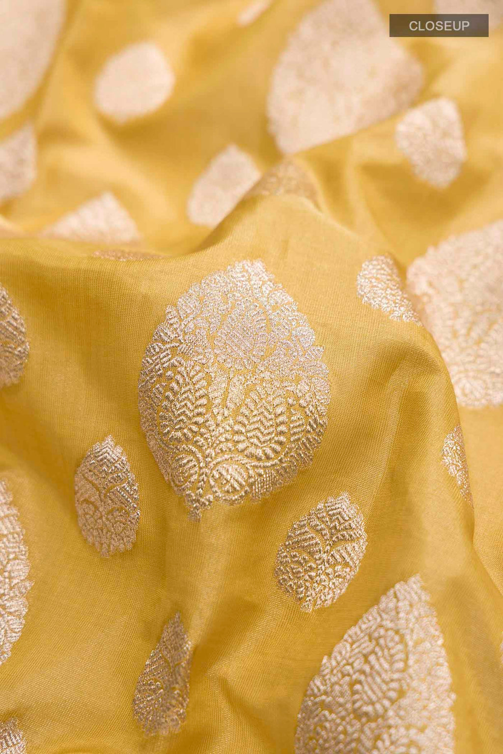 Close up of Yellow Banarasi Silk Saree with Zari Butta on the body and Zari Border displaying folds