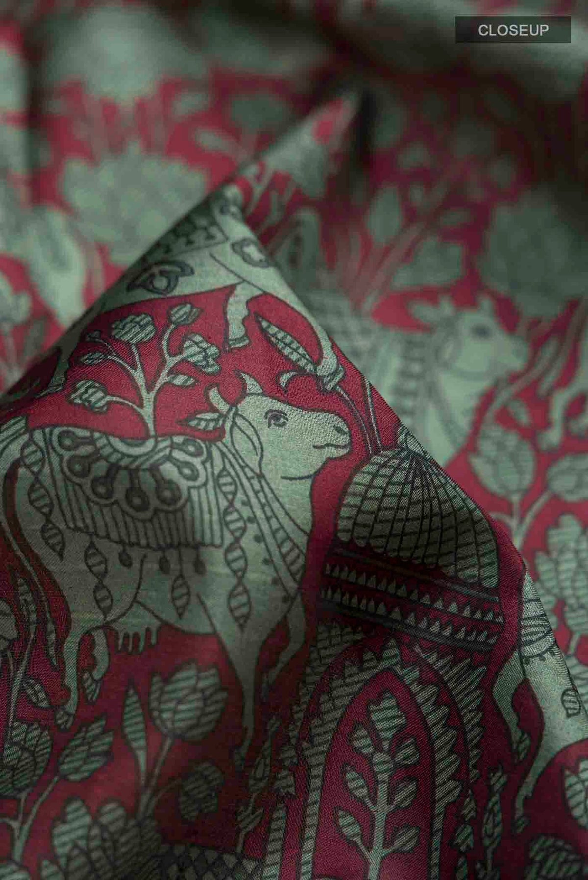 Close up of Maroon Printed Silk Saree with Printed design on the body and Plain Border displaying folds
