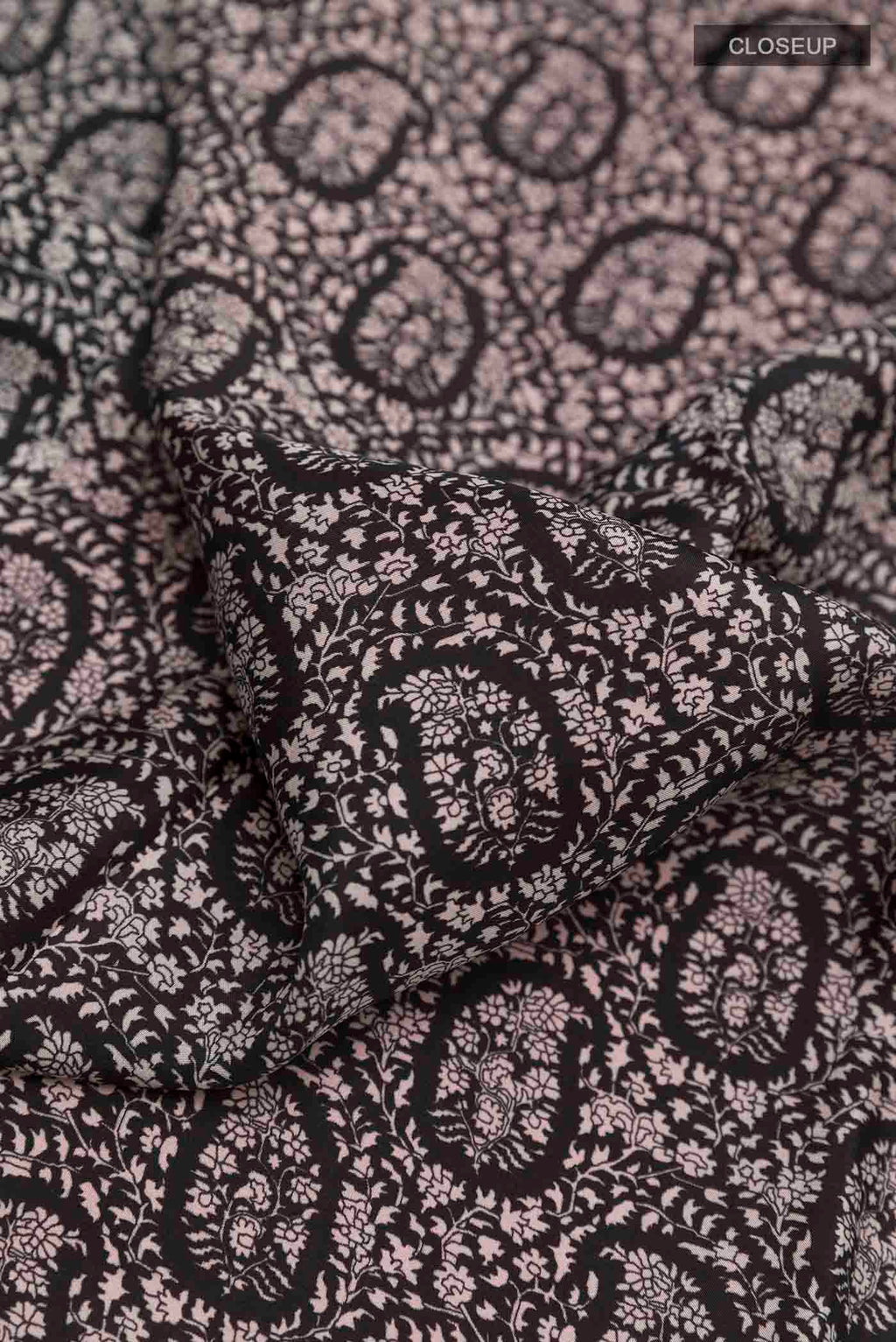 Close up of Black Printed Silk Saree with Printed design on the body and Plain Border displaying folds