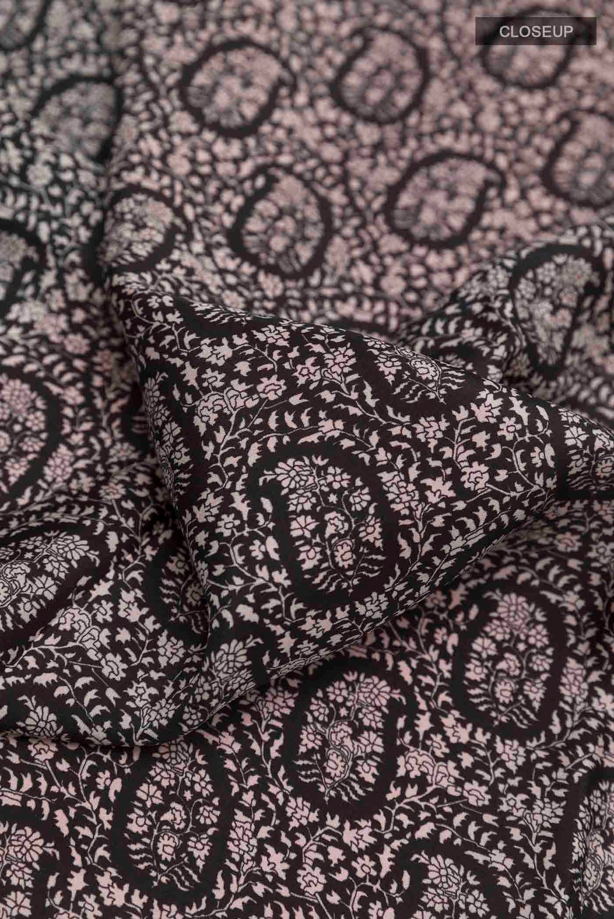 Close up of Black Printed Silk Saree with Printed design on the body and Plain Border displaying folds