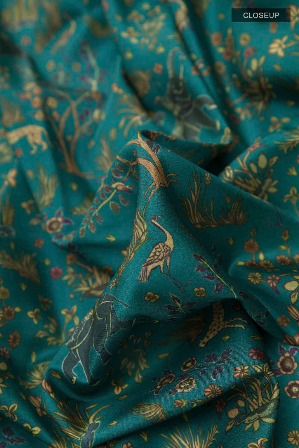 Close up of Green Printed Silk Saree with Printed design on the body and Zari Border displaying folds
