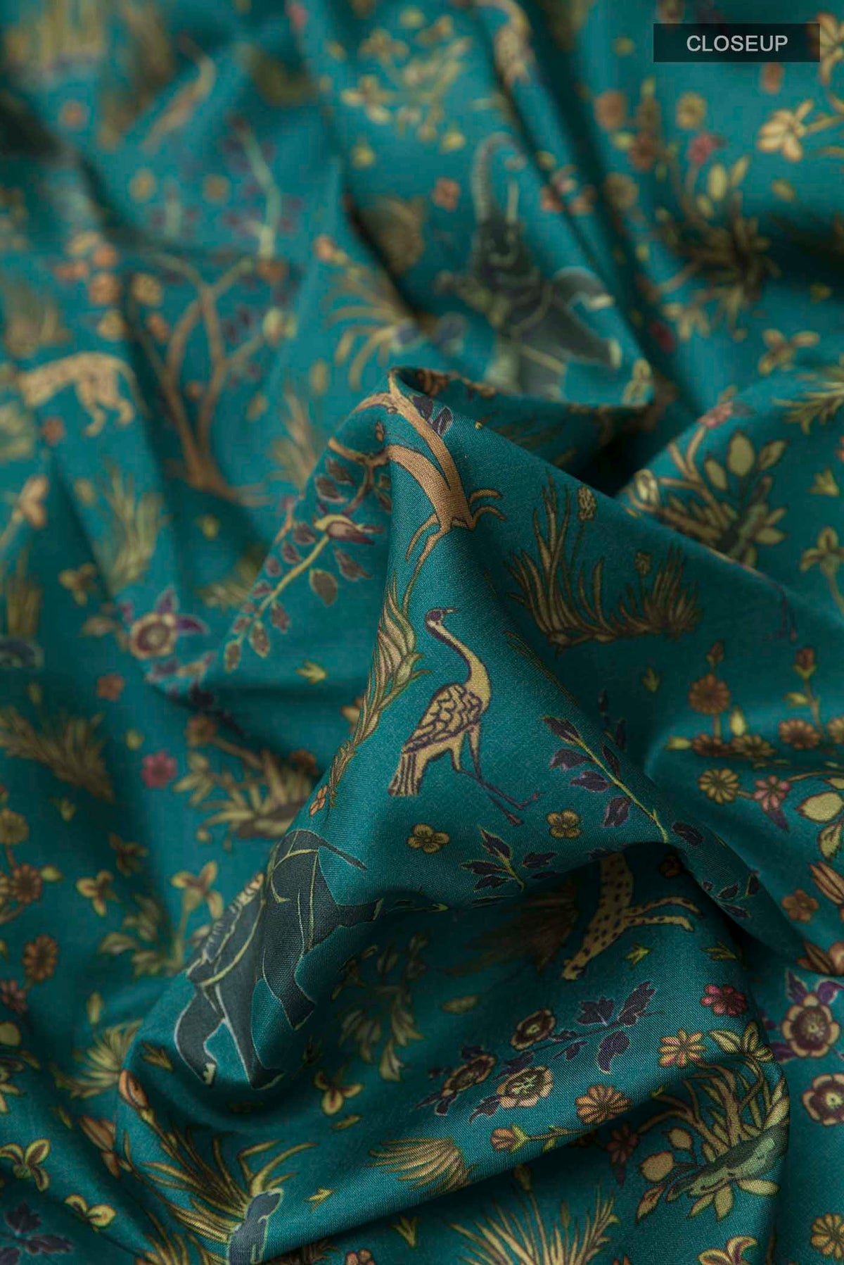 Close up of Green Printed Silk Saree with Printed design on the body and Zari Border displaying folds