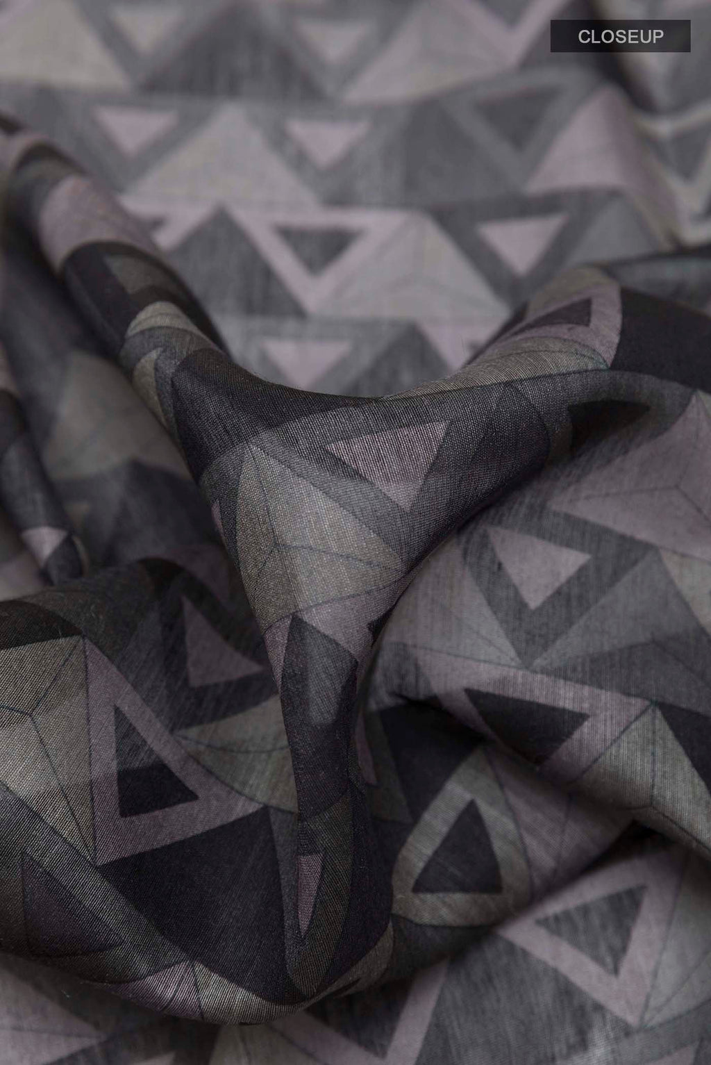 Close up of Grey Tussar Saree with Printed design on the body and Zari Border displaying folds