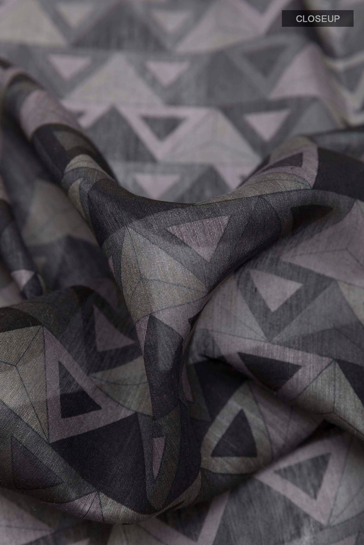 Close up of Grey Tussar Saree with Printed design on the body and Zari Border displaying folds