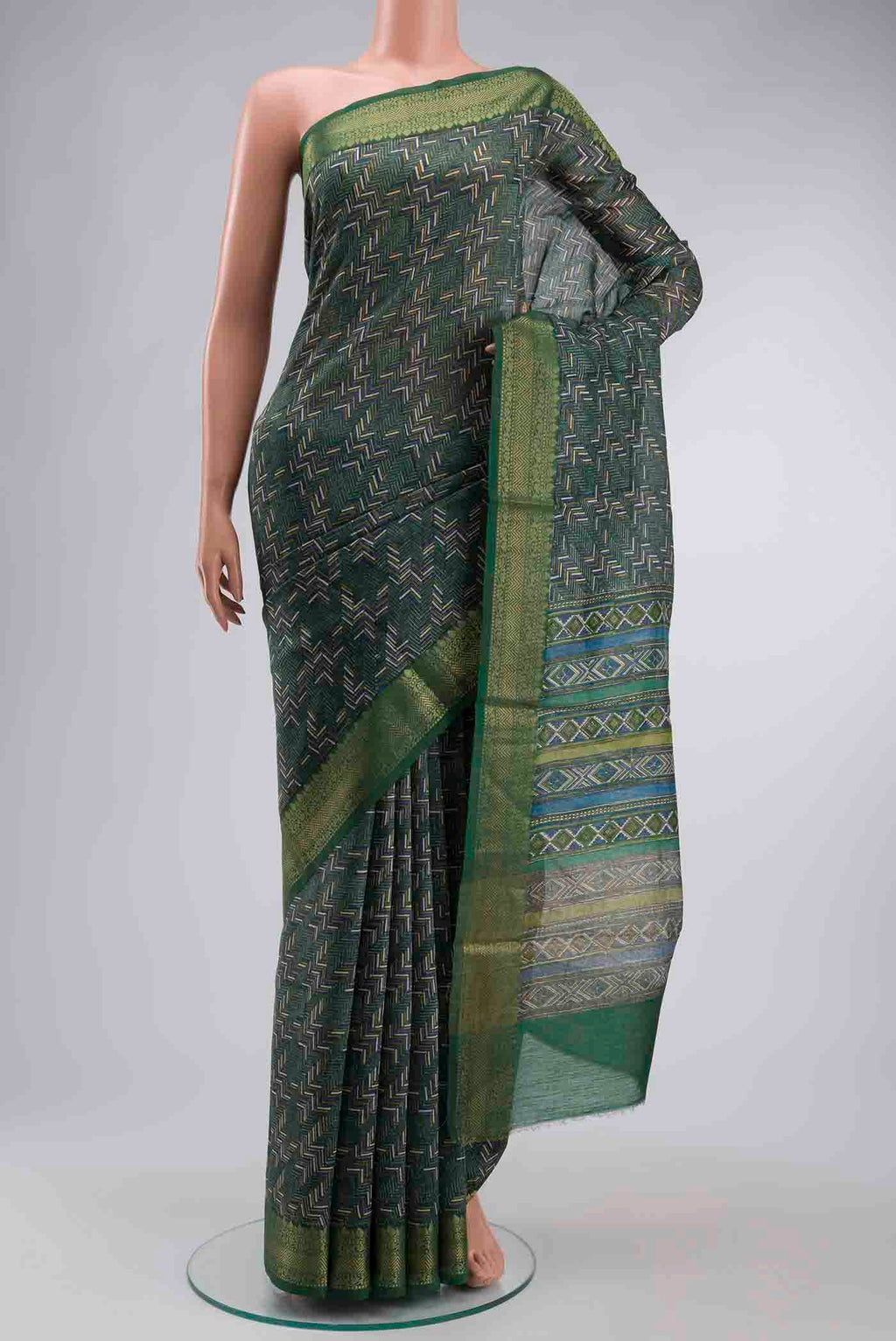 Green Tussar Silk Saree with Printed design on the body and Zari Border displayed on a mannequin