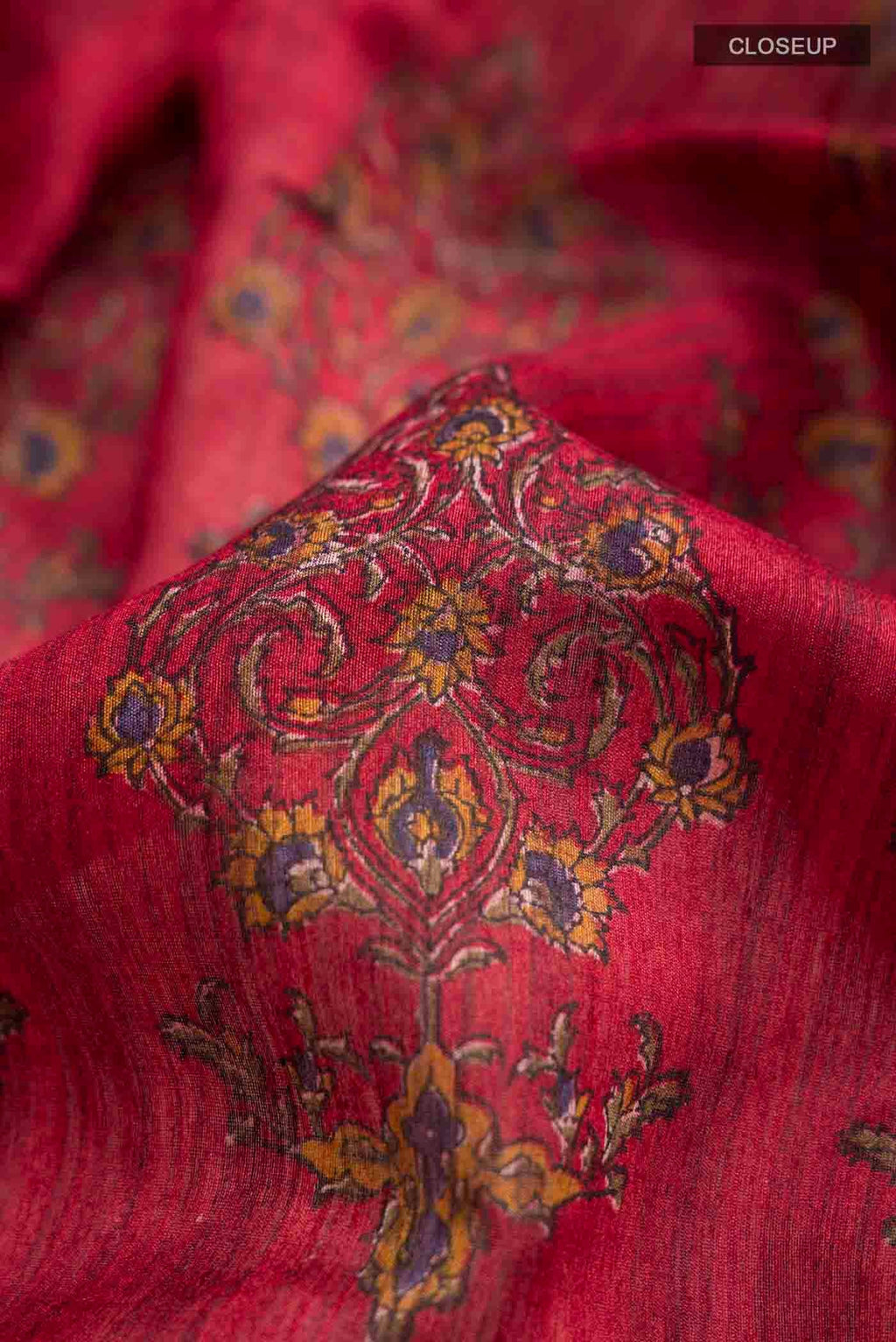 Close up of Red Tussar Silk Saree with Printed design on the body and Zari Border displaying folds