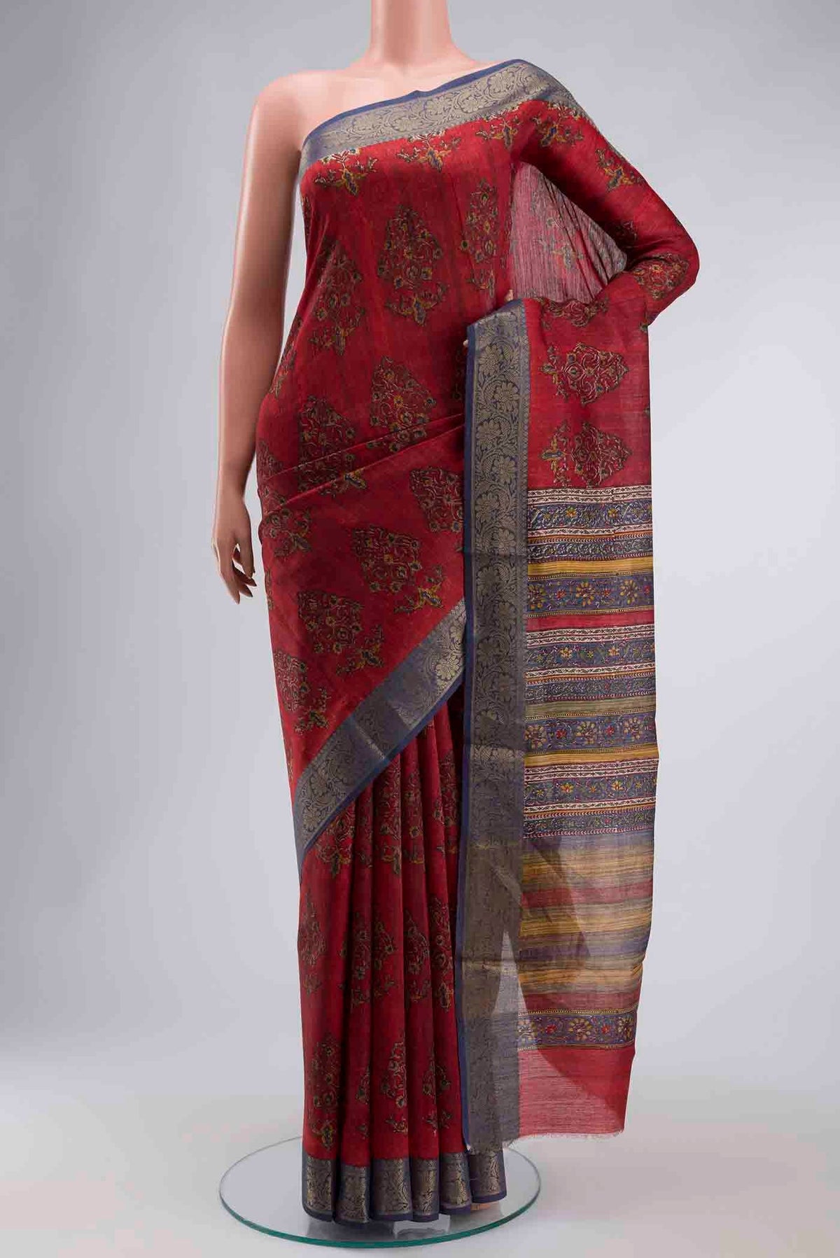 Red Tussar Silk Saree with Printed design on the body and Zari Border displayed on a mannequin