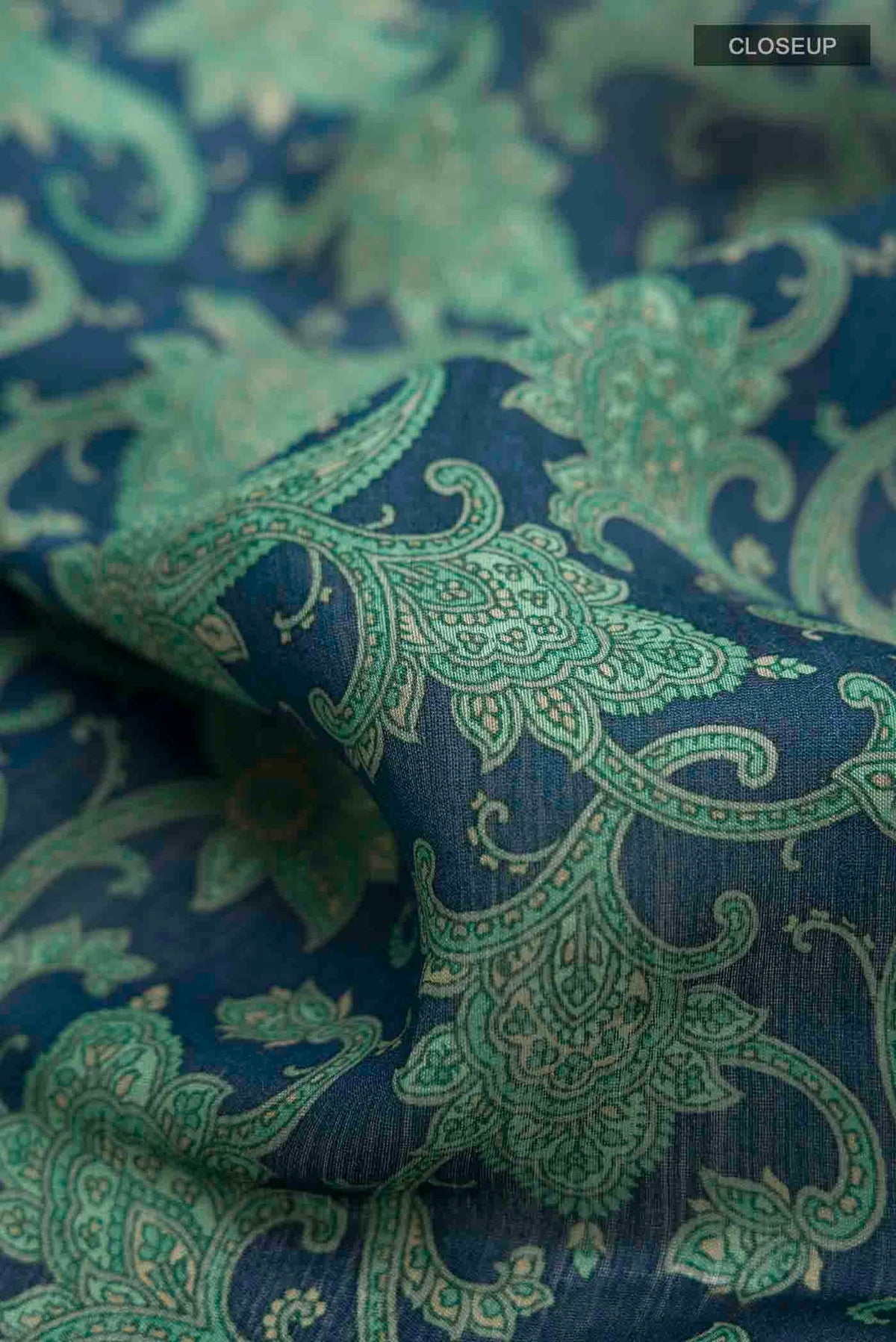 Close up of Blue Tussar Silk Saree with Printed design on the body and Zari And Thread Border displaying folds