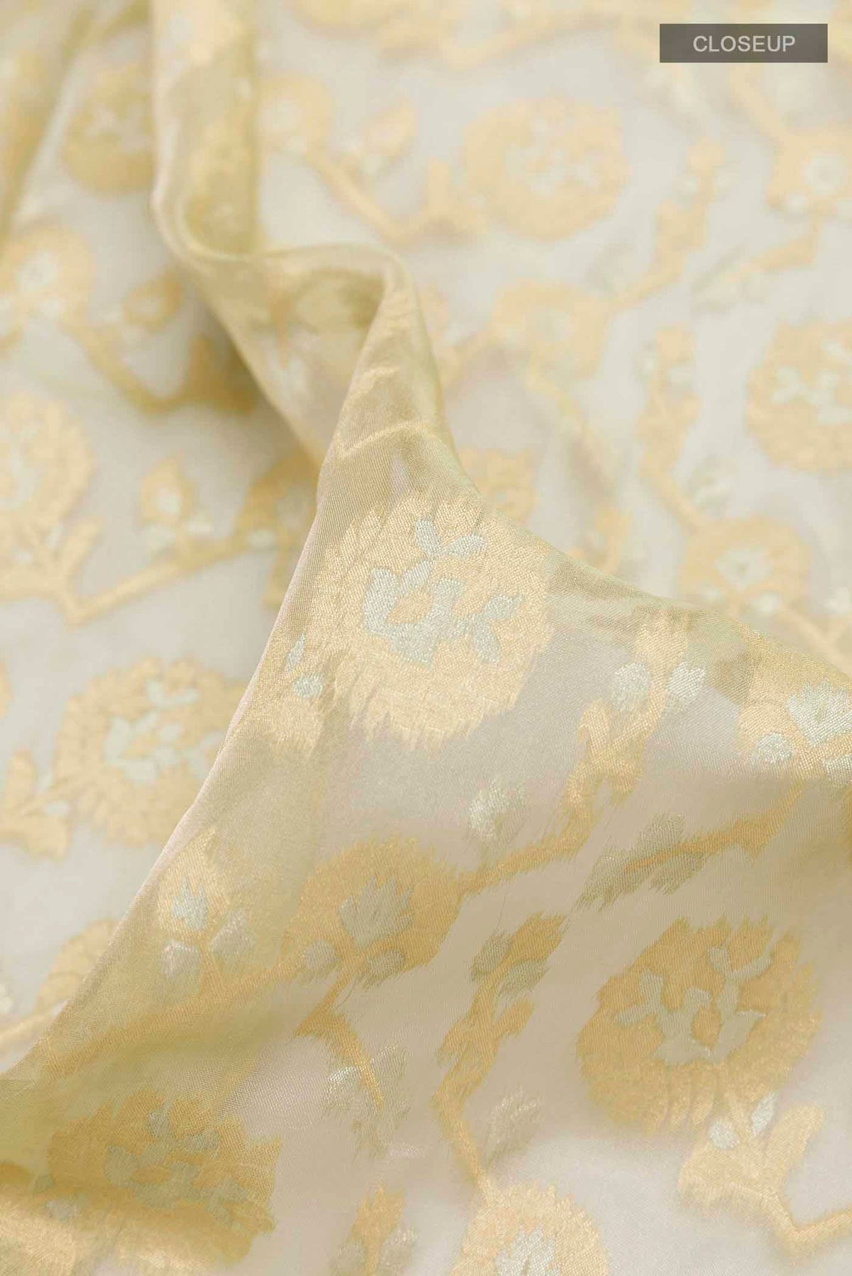 Close up of Green Banarasi Kora Silk Saree with Zari Brocade on the body and Zari Border displaying folds