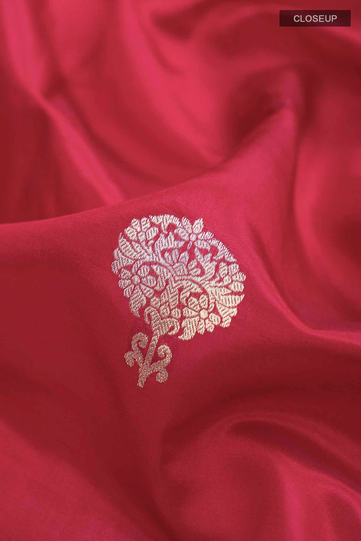 Close up of Red Banarasi Katan Silk Saree with Zari Butta on the body and Plain Border displaying folds