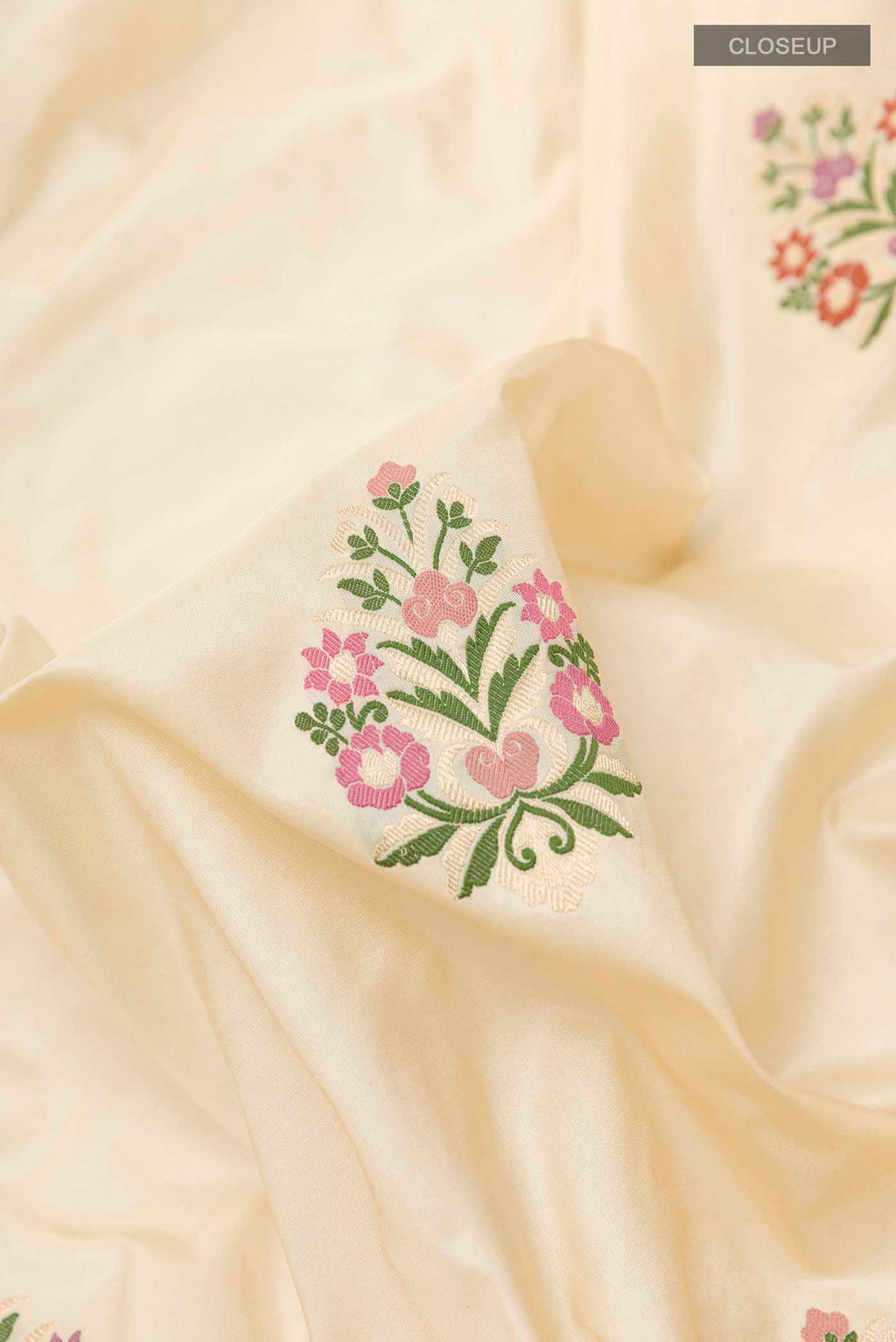 Close up of Cream Banarasi Silk Saree with Zari Butta on the body and Zari Border displaying folds