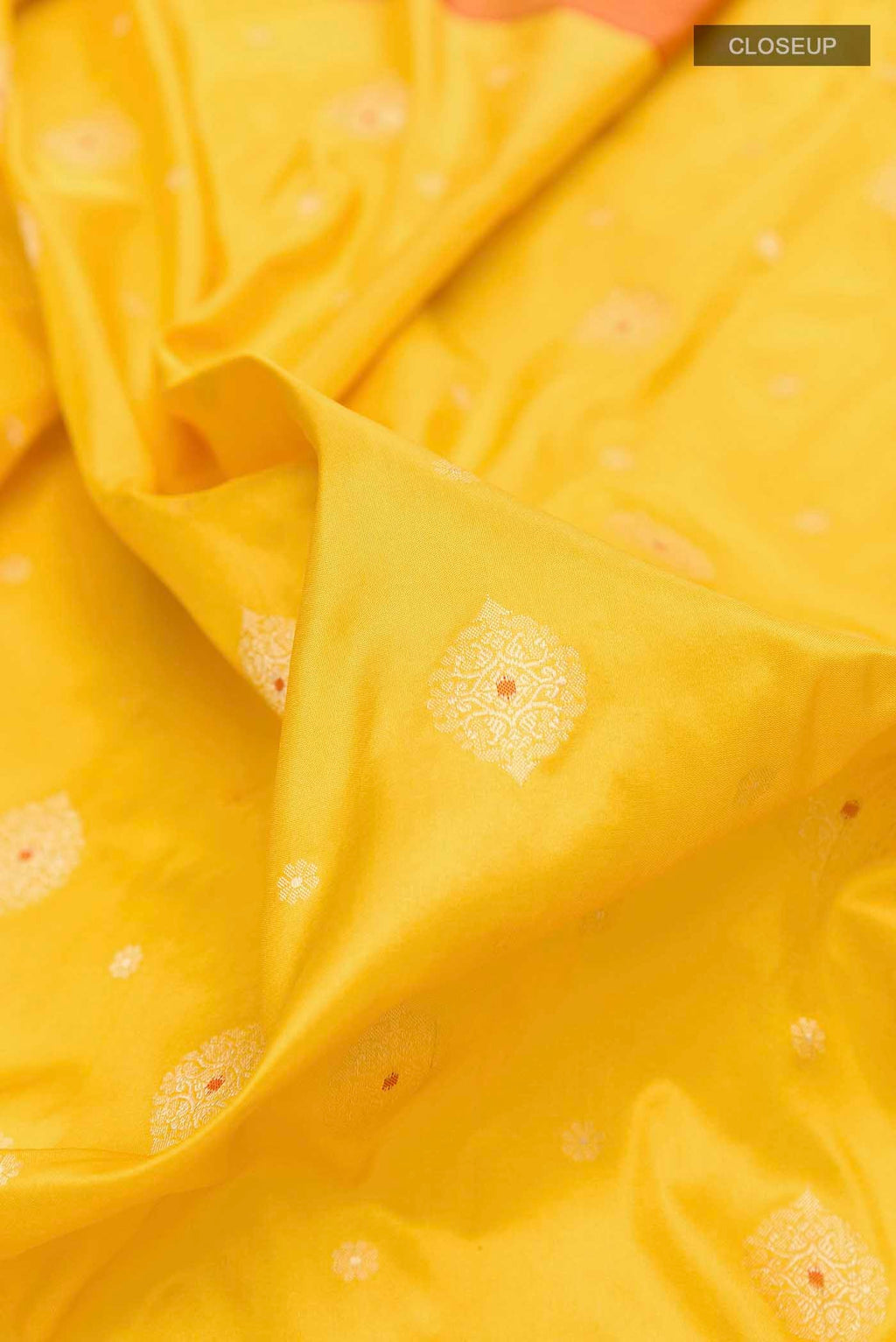 Close up of Yellow Banarasi Silk Saree with Zari Butta on the body and Zari Border displaying folds