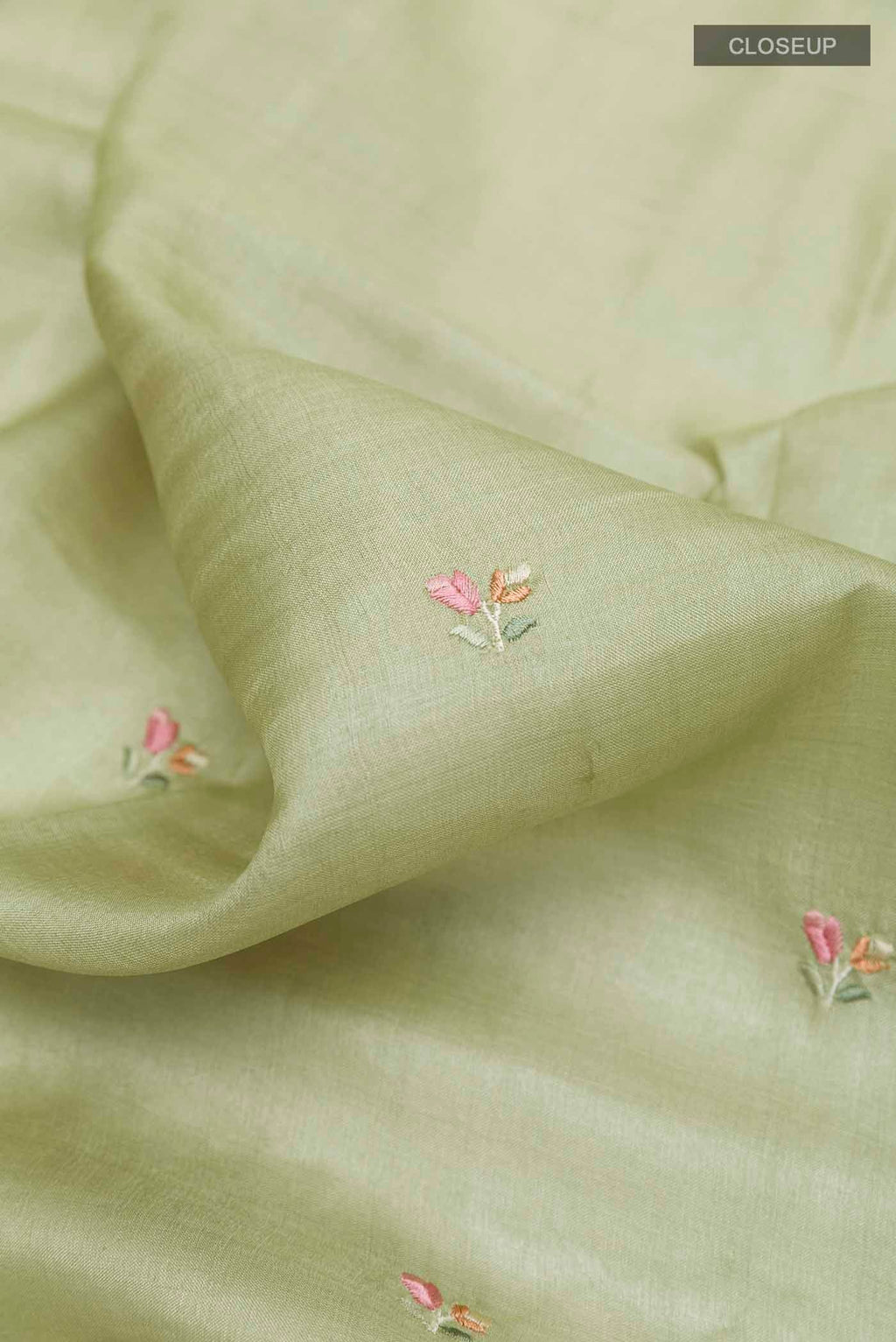 Close up of Sage Green Tussar Saree with Thread Butta on the body and Embroidery Border displaying folds