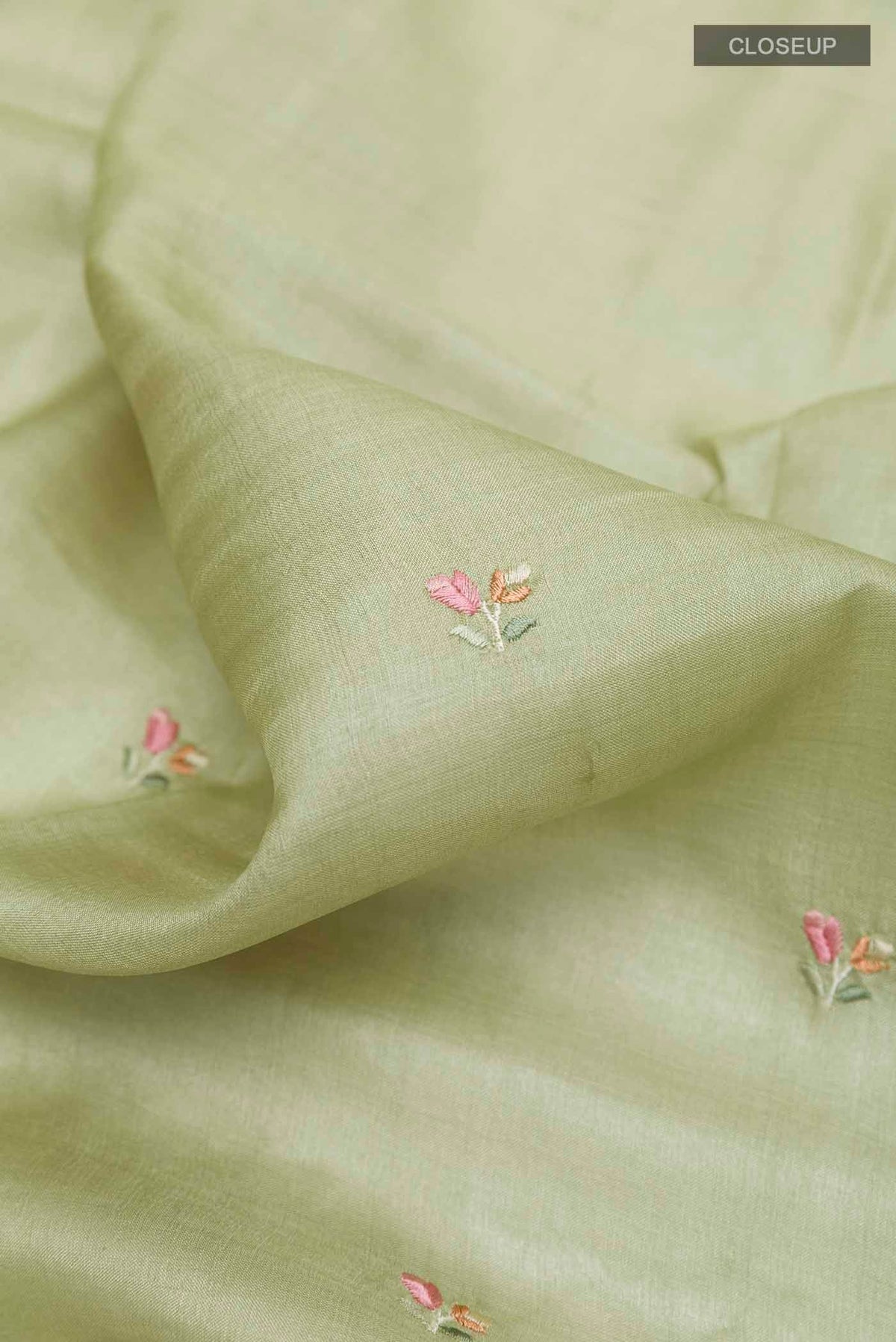 Close up of Sage Green Tussar Saree with Thread Butta on the body and Embroidery Border displaying folds